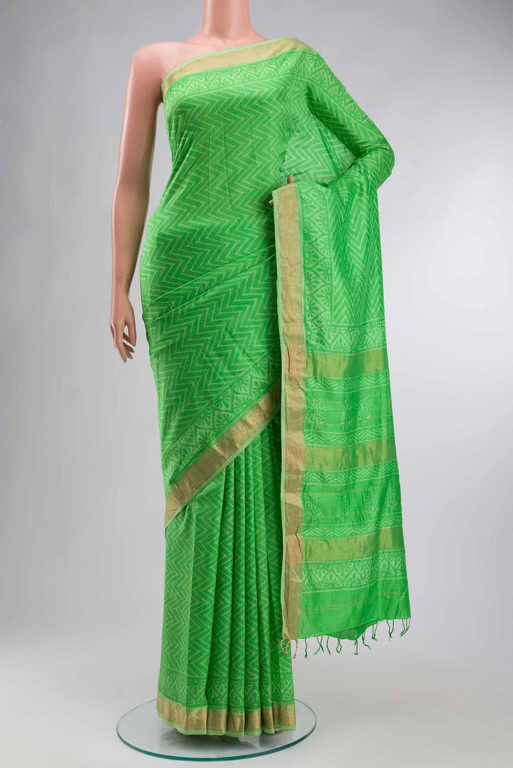 Green Printed Silk Saree with Printed design on the body and Zari Border displayed on a mannequin