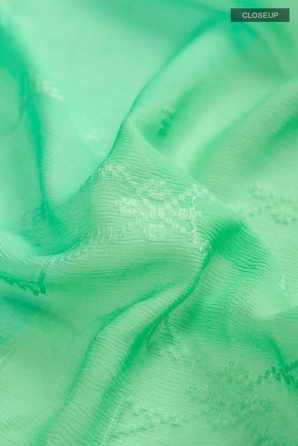 Close up of Green Mysore Chiffon Saree with Embroidery on the body and Zari Border displaying folds