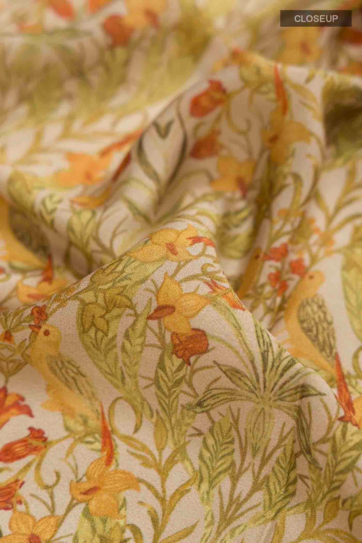 Close up of Green Mysore Crepe Saree with Printed design on the body and Zari Border displaying folds