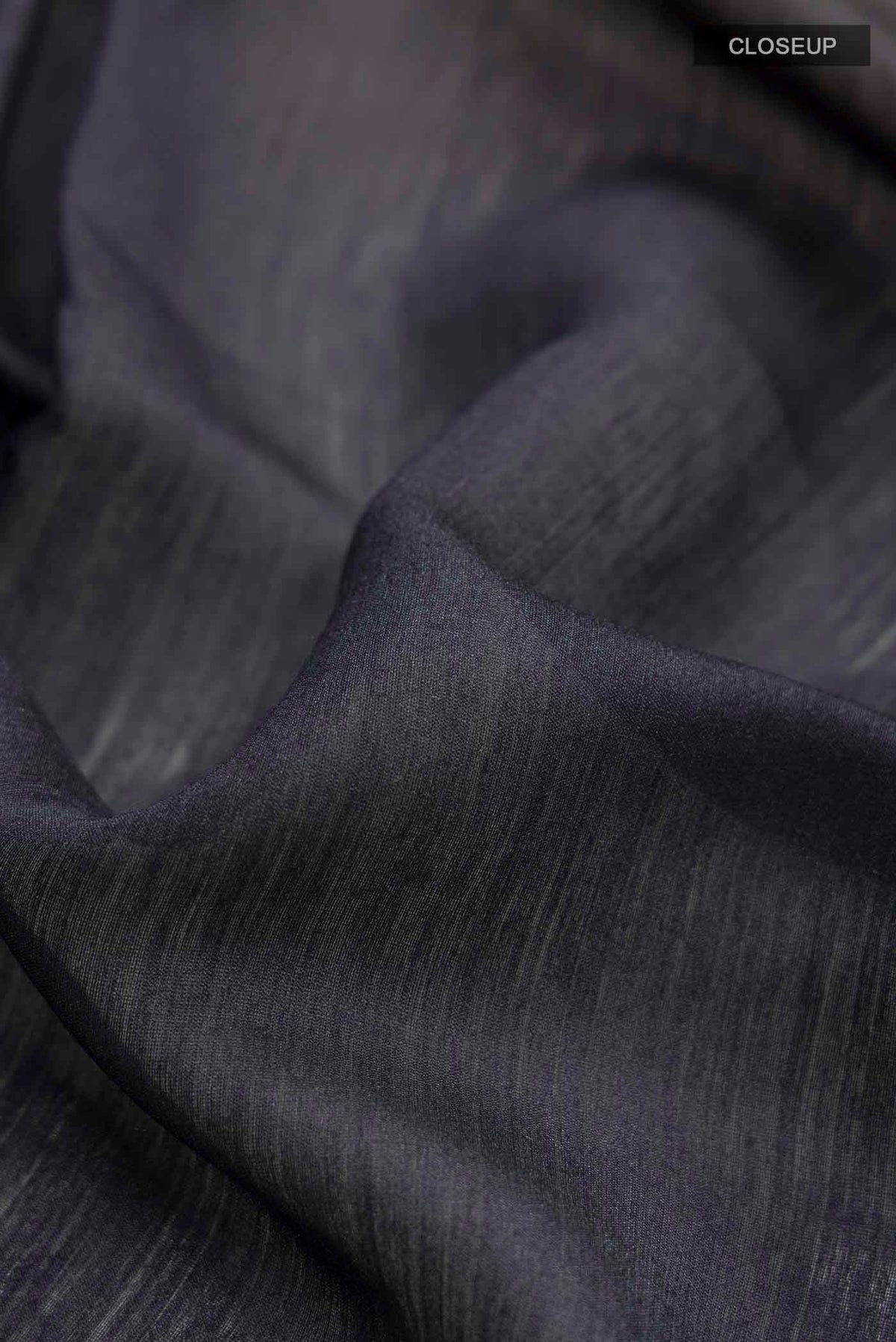 Close up of Black Bhagalpuri Tussar Silk Saree with Embroidery on the body and Zari Border displaying folds