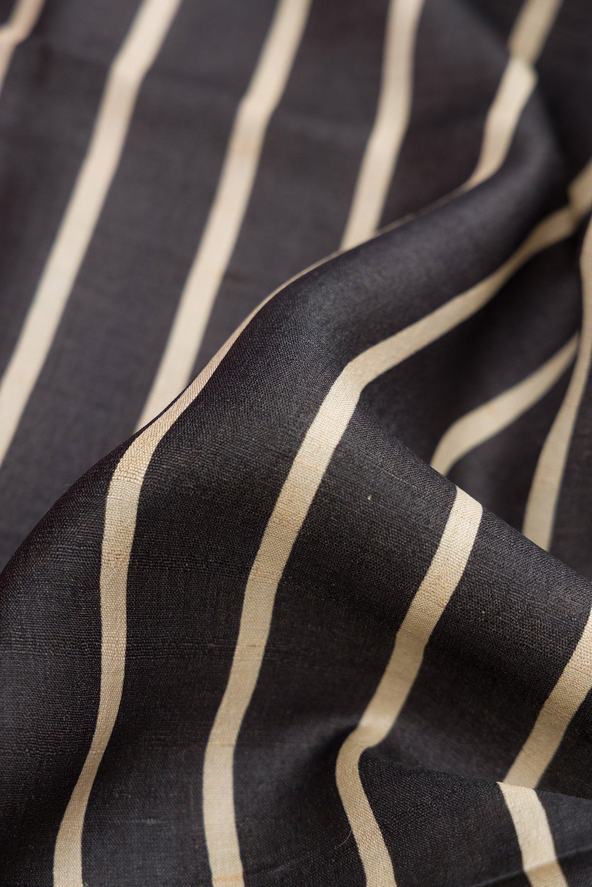 Close up of Black Dual Tone Tussar Silk Saree with Stripes on the body and Embroidery Border.  displaying folds