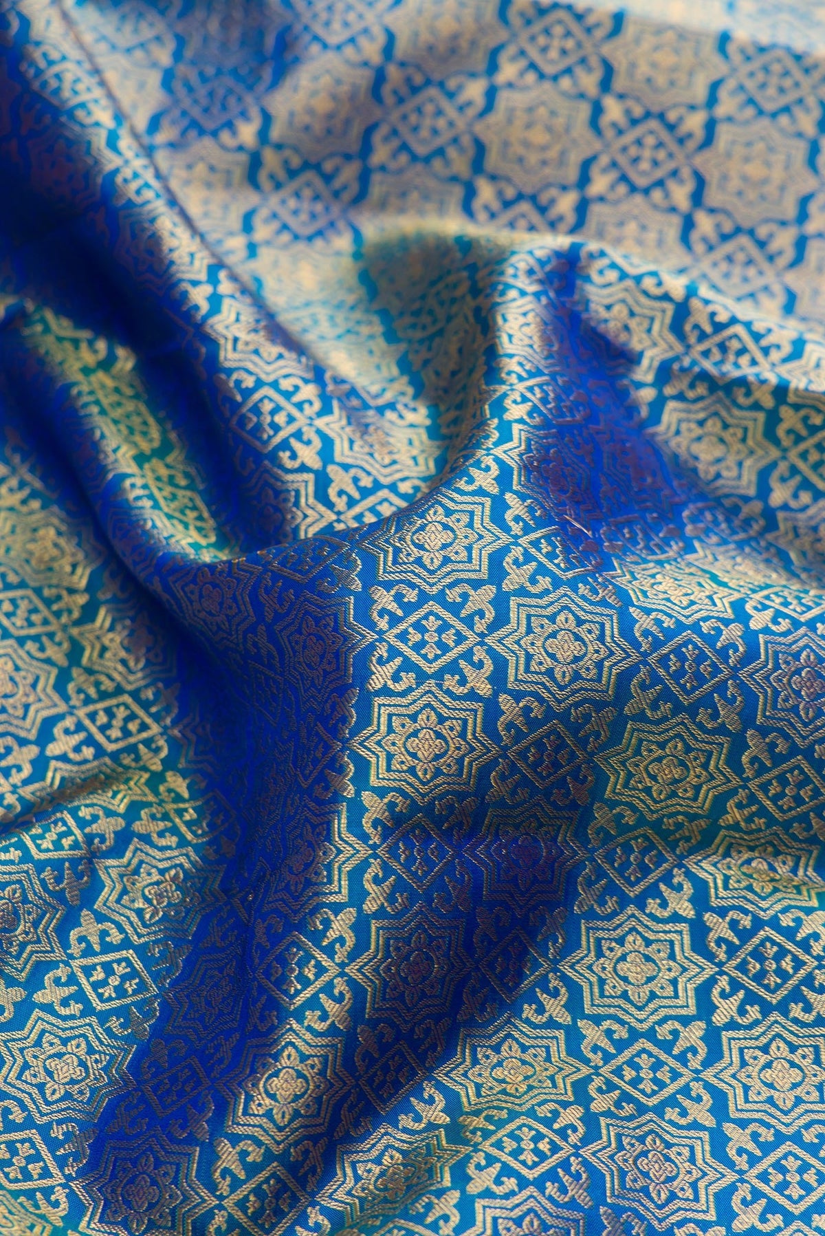 Close up of Peacock Blue Dual Tone Kanchipuram Silk Saree with Zari Brocade on the body and Zari Border.  displaying folds