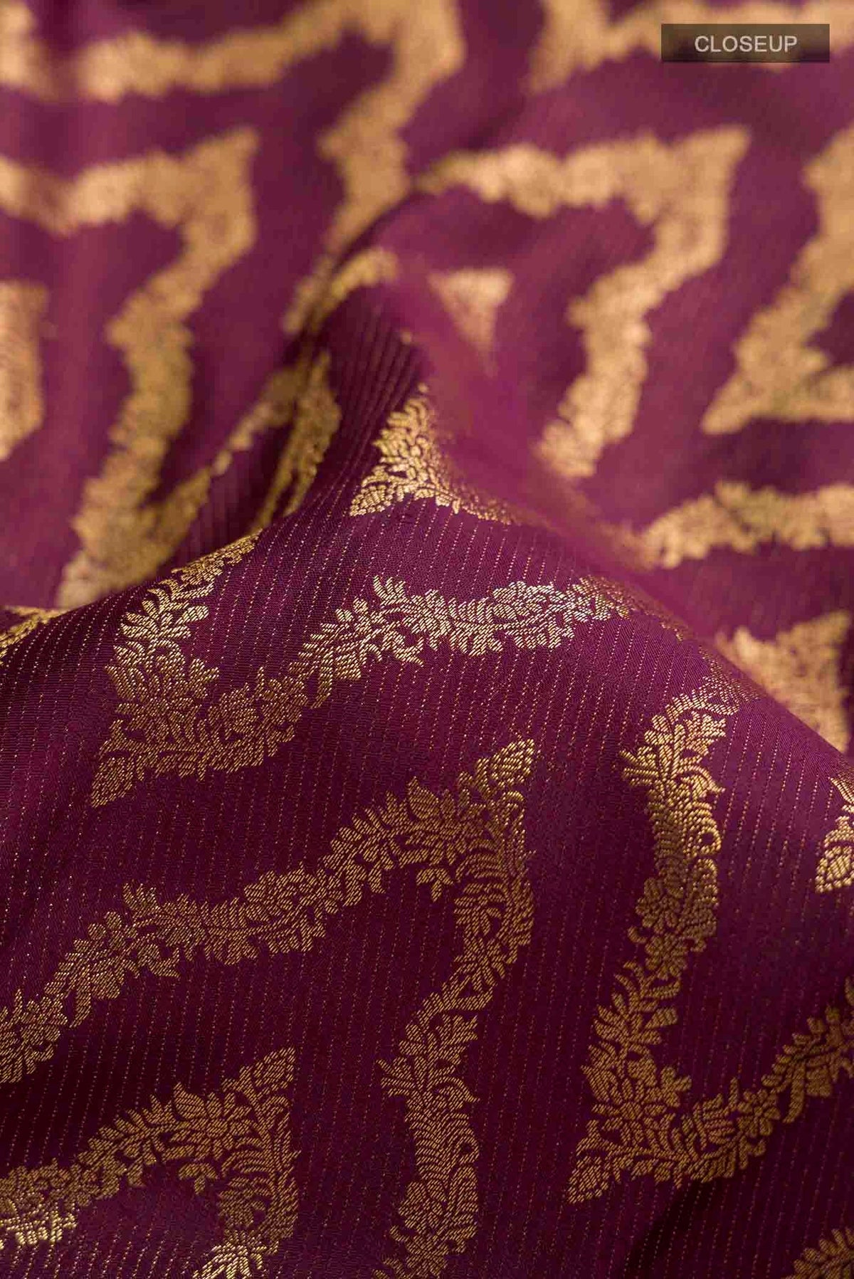 Close up of Burgundy Kanchipuram Silk Saree with Zari Brocade on the body and Zari Border displaying folds