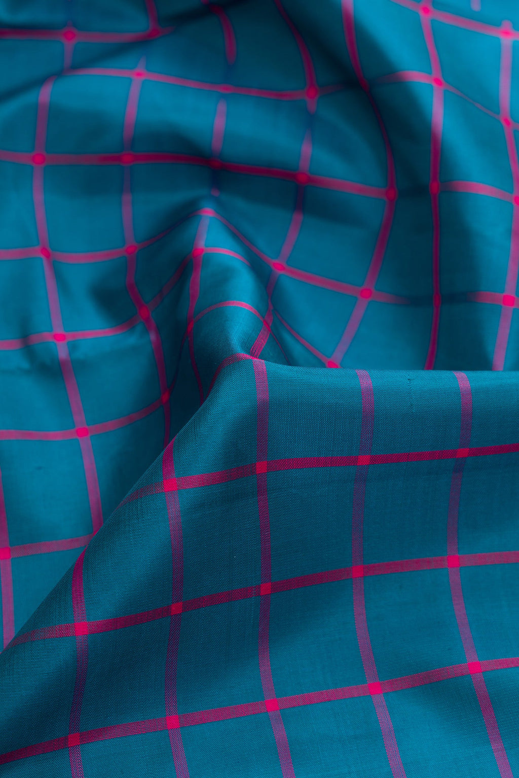 Close up of Peacock Blue Dual Tone Kanjivaram Silk Saree with Checked design on the body and Zari Border.  displaying folds