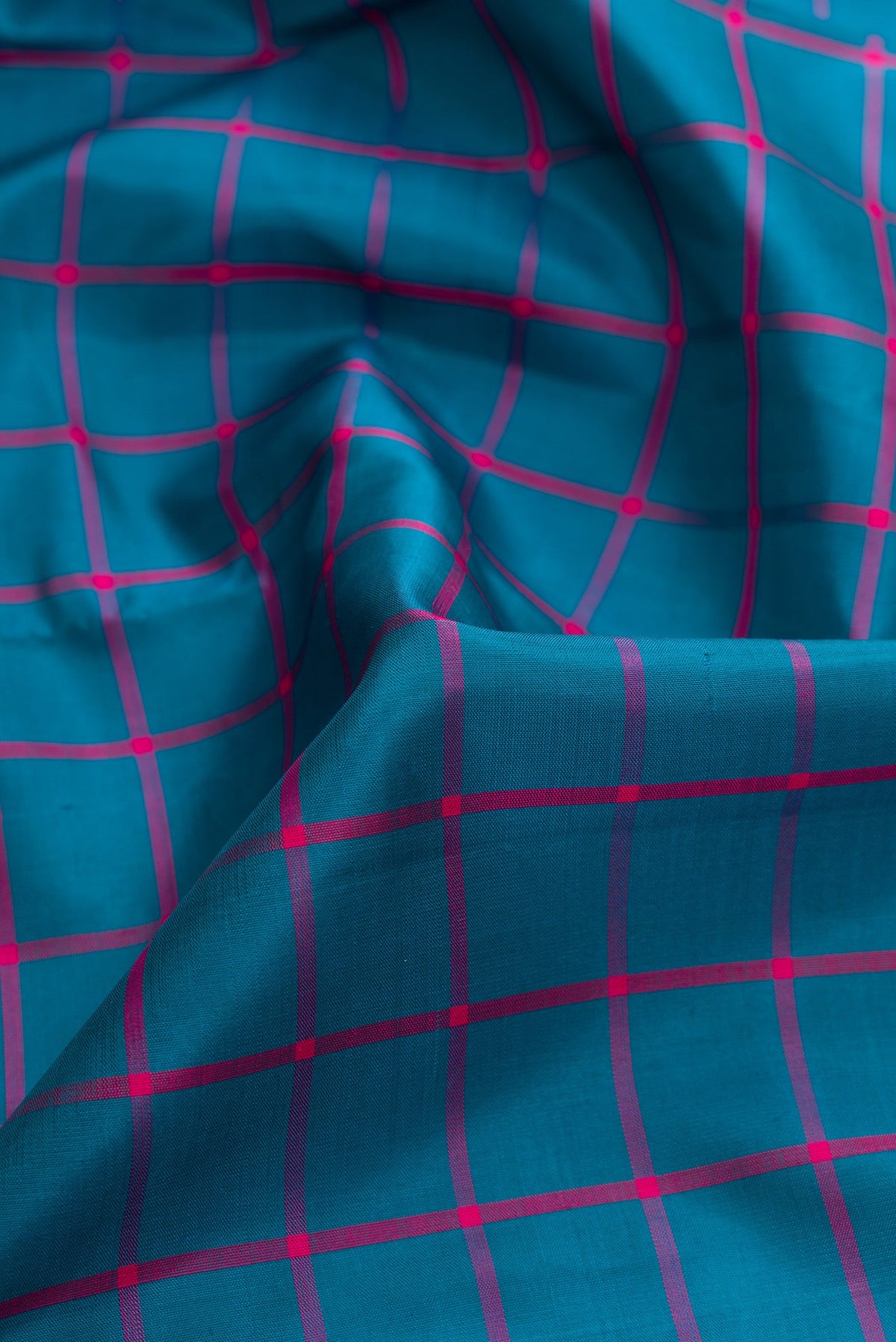 Close up of Peacock Blue Dual Tone Kanjivaram Silk Saree with Checked design on the body and Zari Border.  displaying folds