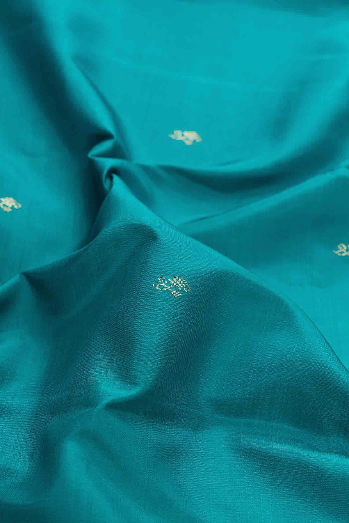 Close up of Peacock Blue Dual Tone Kanchipuram Silk Saree with Zari Butta on the body and Zari Border displaying folds