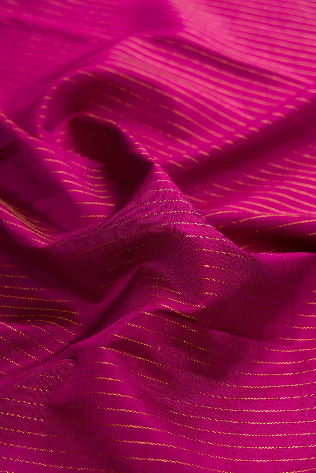 Close up of Magenta Kanchipuram Silk Saree with Stripes on the body and One Side Border displaying folds