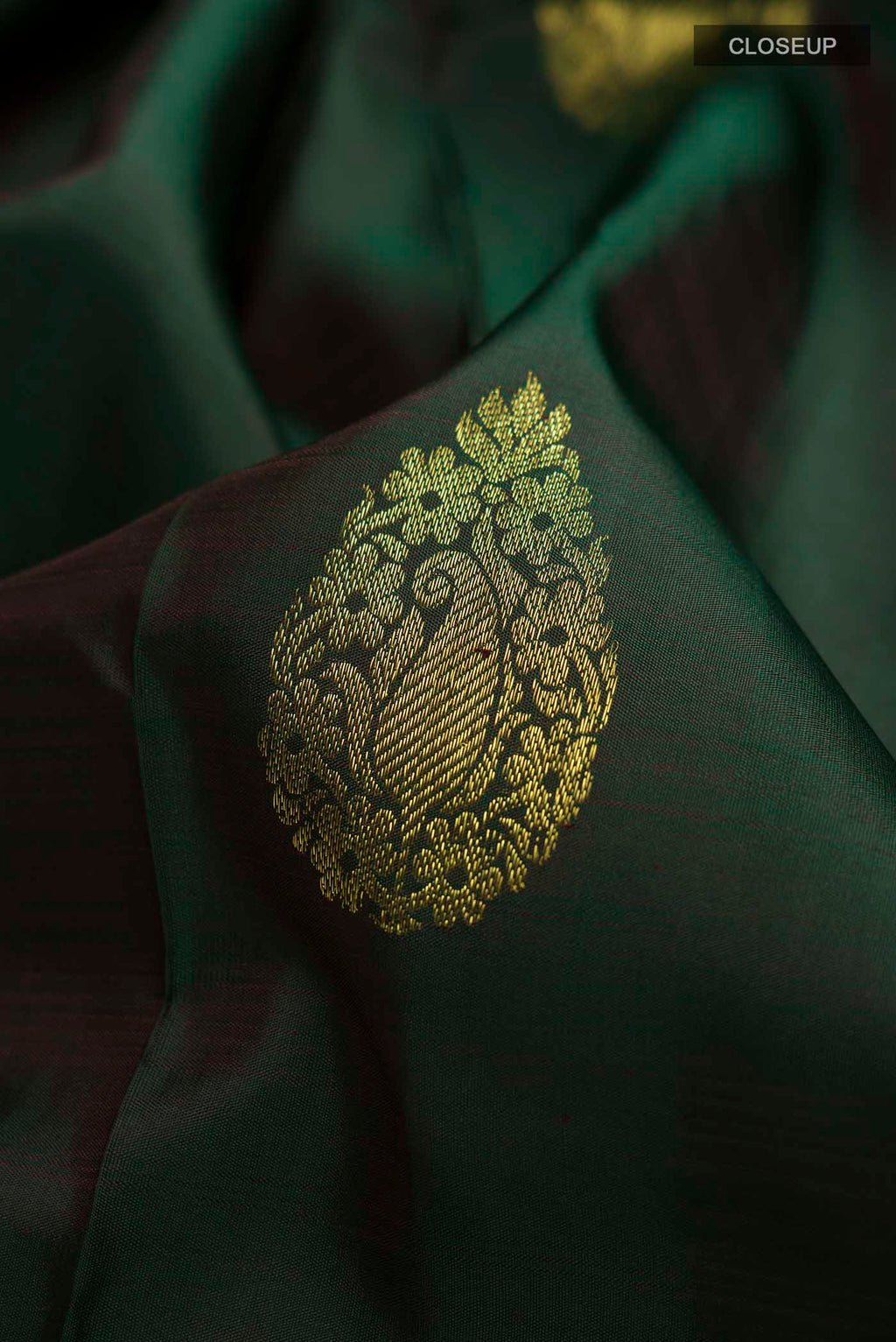 Close up of Green Kanchipuram Silk Saree with Zari Butta on the body and Zari Border displaying folds