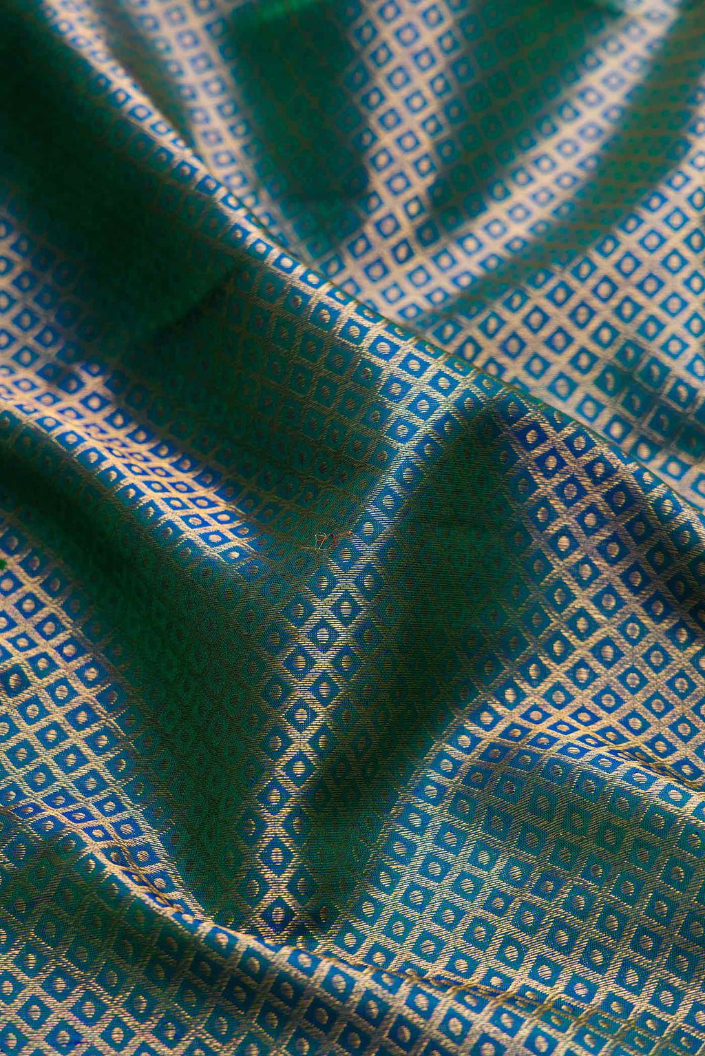 Close up of Peacock Blue Dual Tone Kanchipuram Silk Saree with Zari Brocade on the body and Zari Border displaying folds