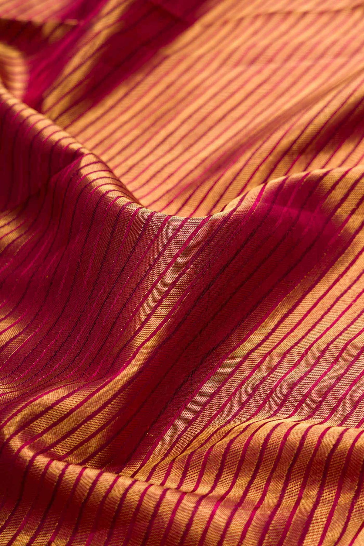 Close up of Maroon Dual Tone Kanchipuram Saree with Zari Brocade on the body and Zari Border displaying folds