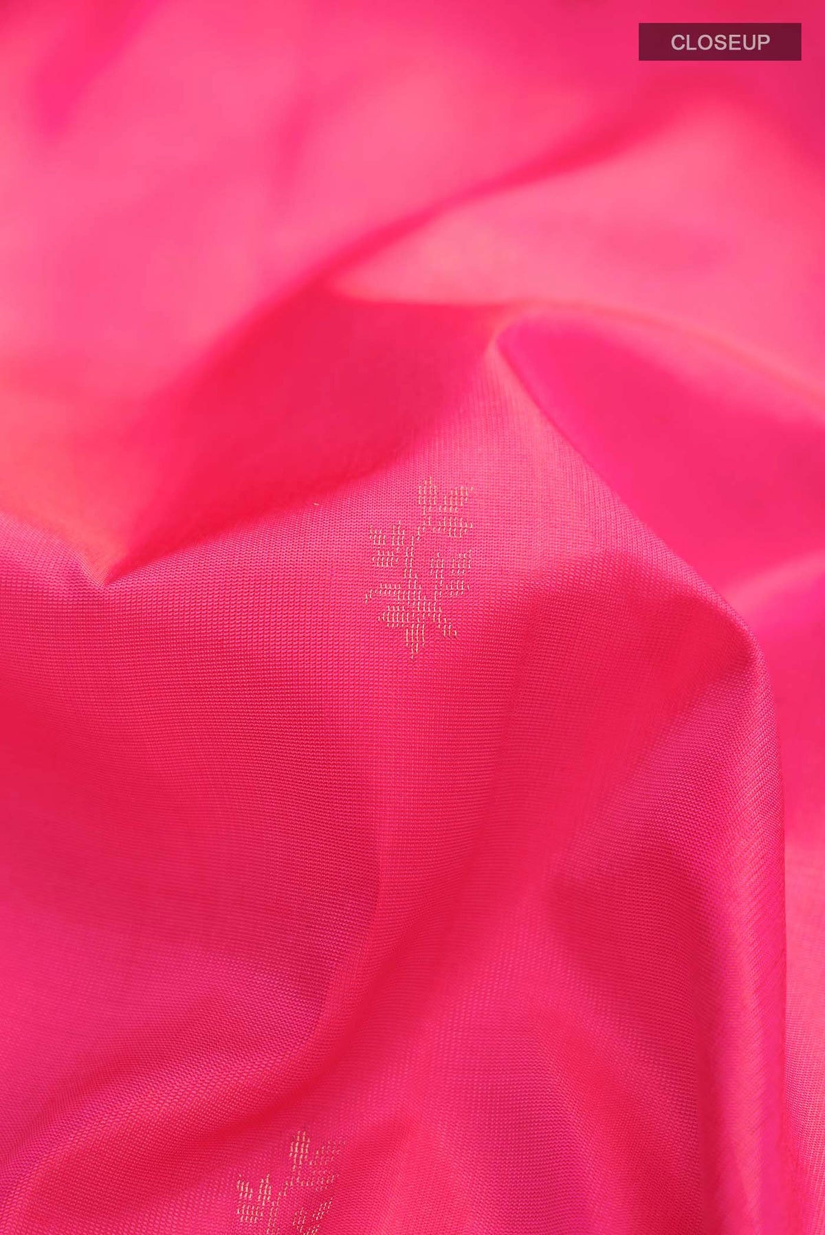 Close up of Pink Soft Silk Saree with Zari Butta on the body and Zari Border displaying folds