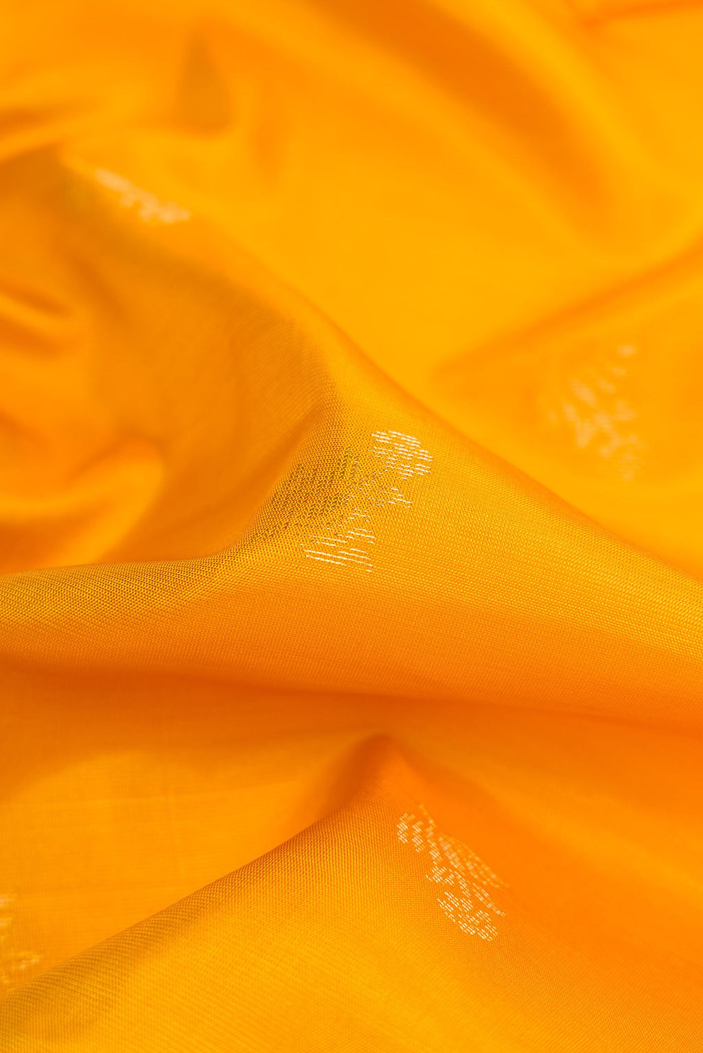 Close up of Mustard Dual Tone Soft Silk Saree with Zari Butta on the body and Zari Border displaying folds