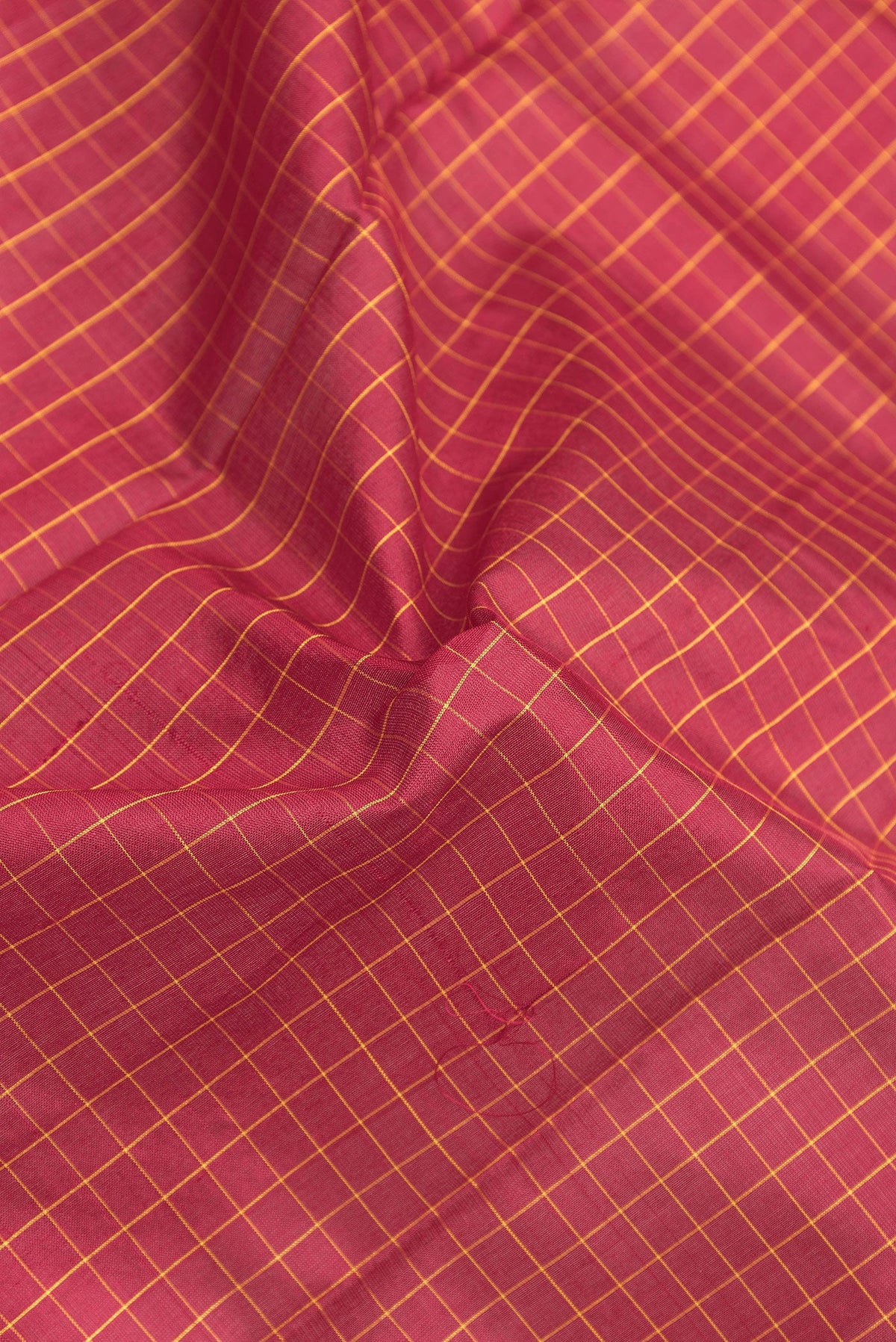 Close up of Maroon Kanjivaram Silk Saree with Checked design on the body and Zari Border.  displaying folds