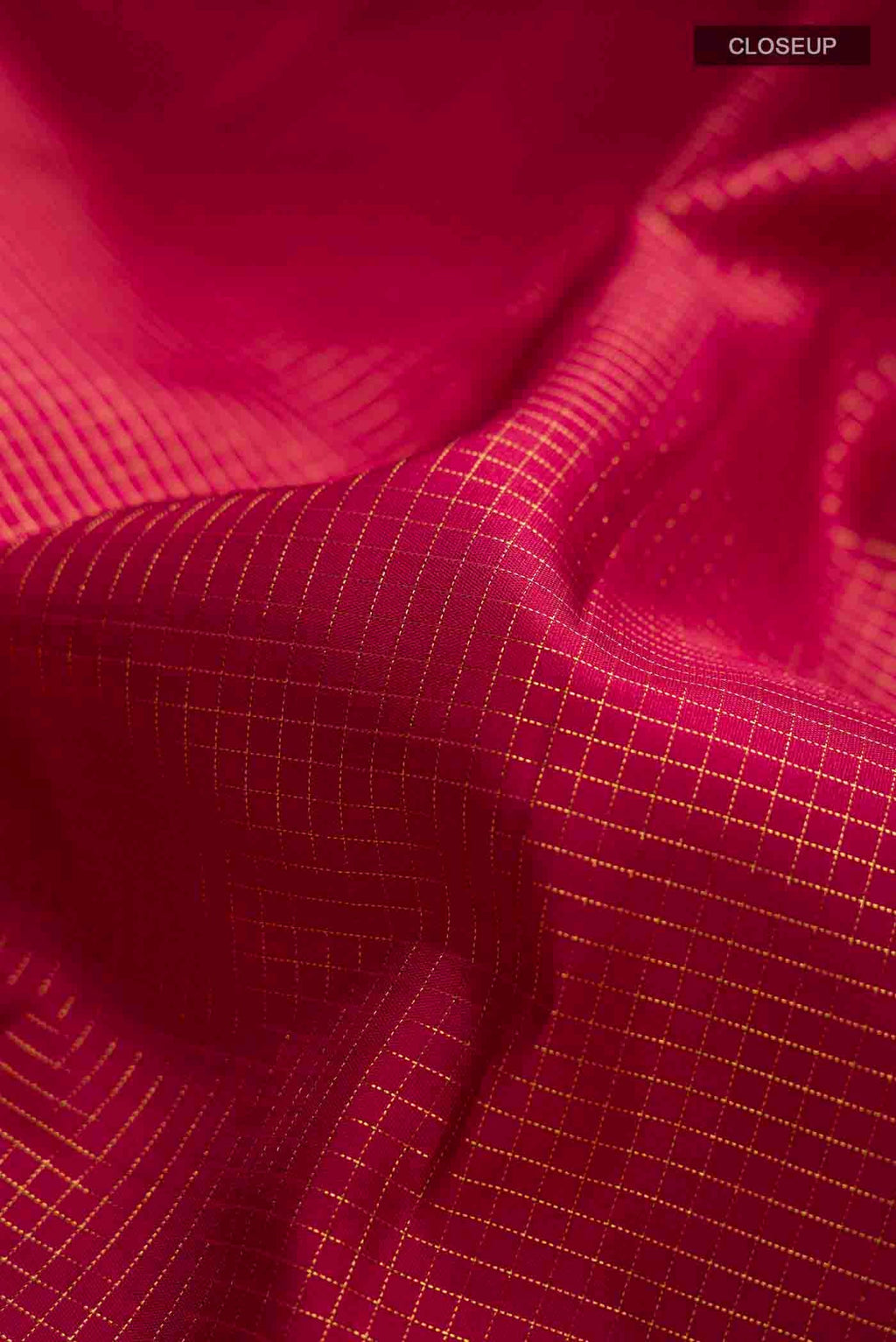 Close up of Maroon Kanchipuram Silk Saree with Checked design on the body and Zari Border displaying folds