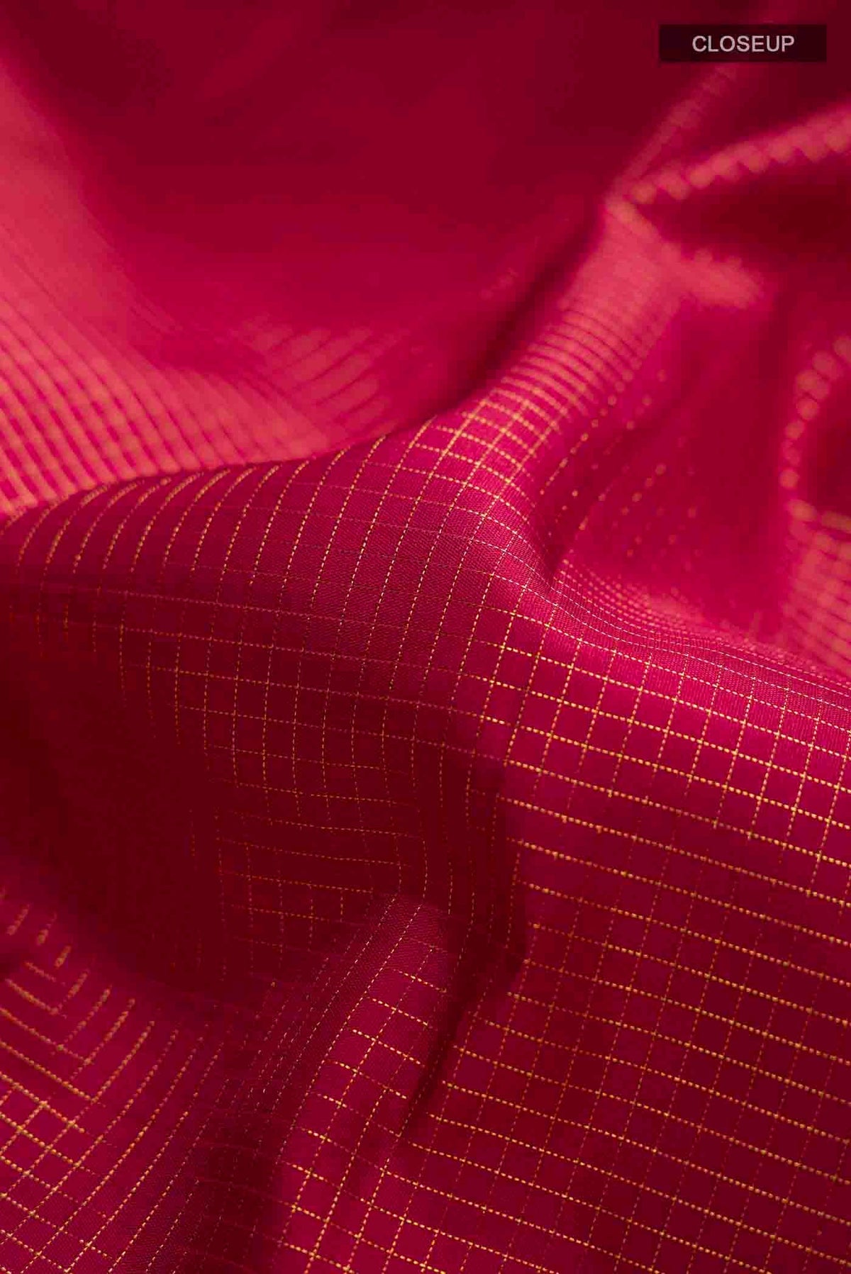 Close up of Maroon Kanchipuram Silk Saree with Checked design on the body and Zari Border displaying folds