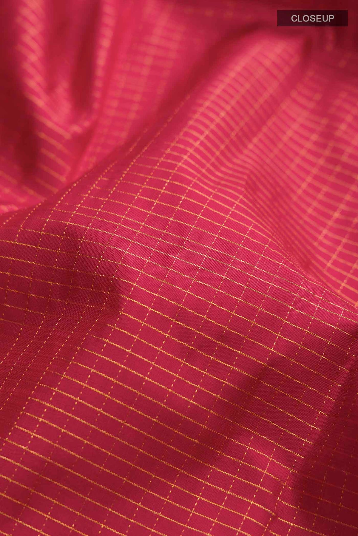 Close up of Maroon Kanchipuram Silk Saree with Checked design on the body and Zari Border displaying folds