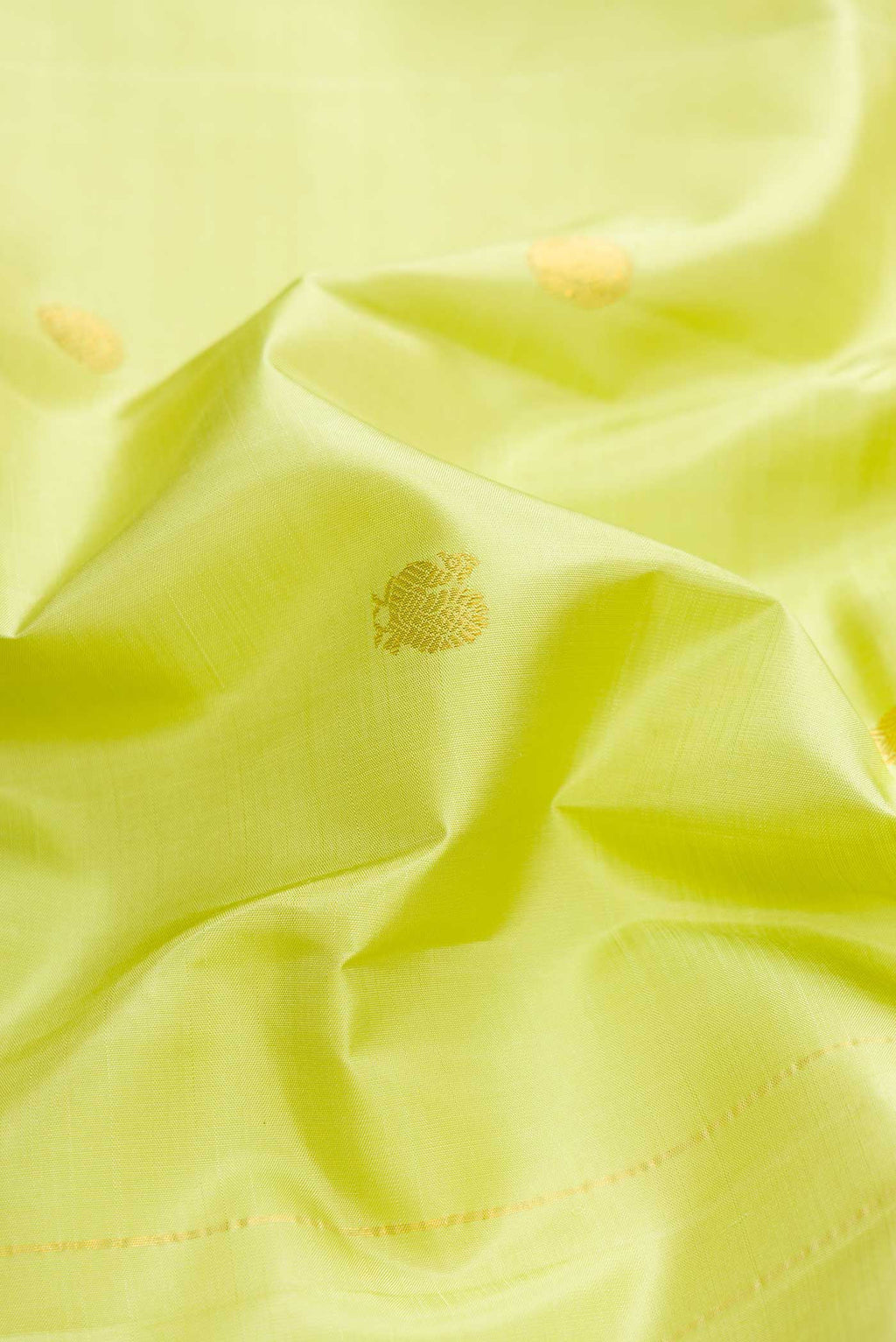 Close up of Green Dual Tone Kanchipuram Silk Saree with Zari Butta on the body and Zari Border displaying folds