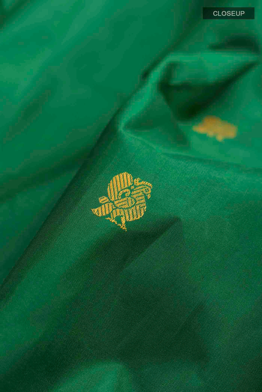 Close up of Green Kanchipuram Silk Saree with Thread Butta on the body and Thread Border displaying folds