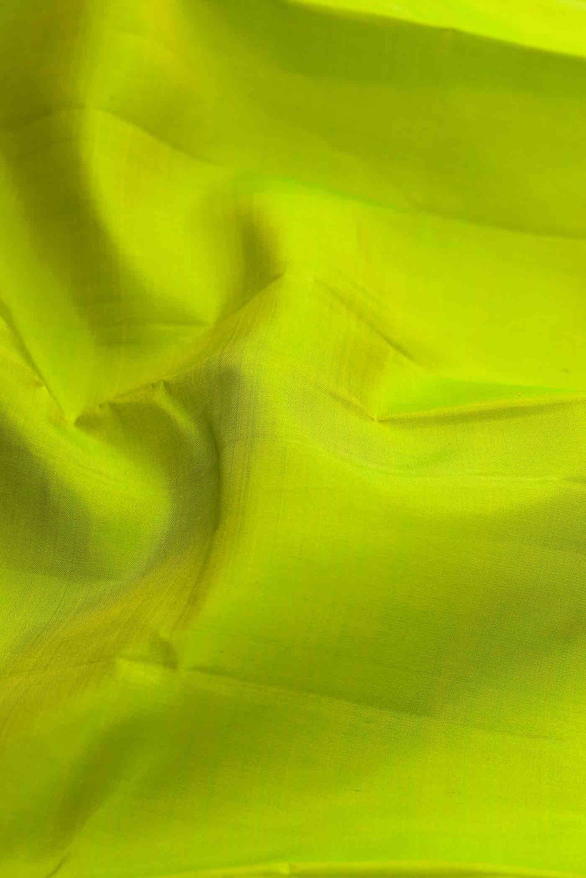 Close up of Parrot Green Dual Tone Kanchipuram Silk Saree with Plain Body and Zari Border displaying folds