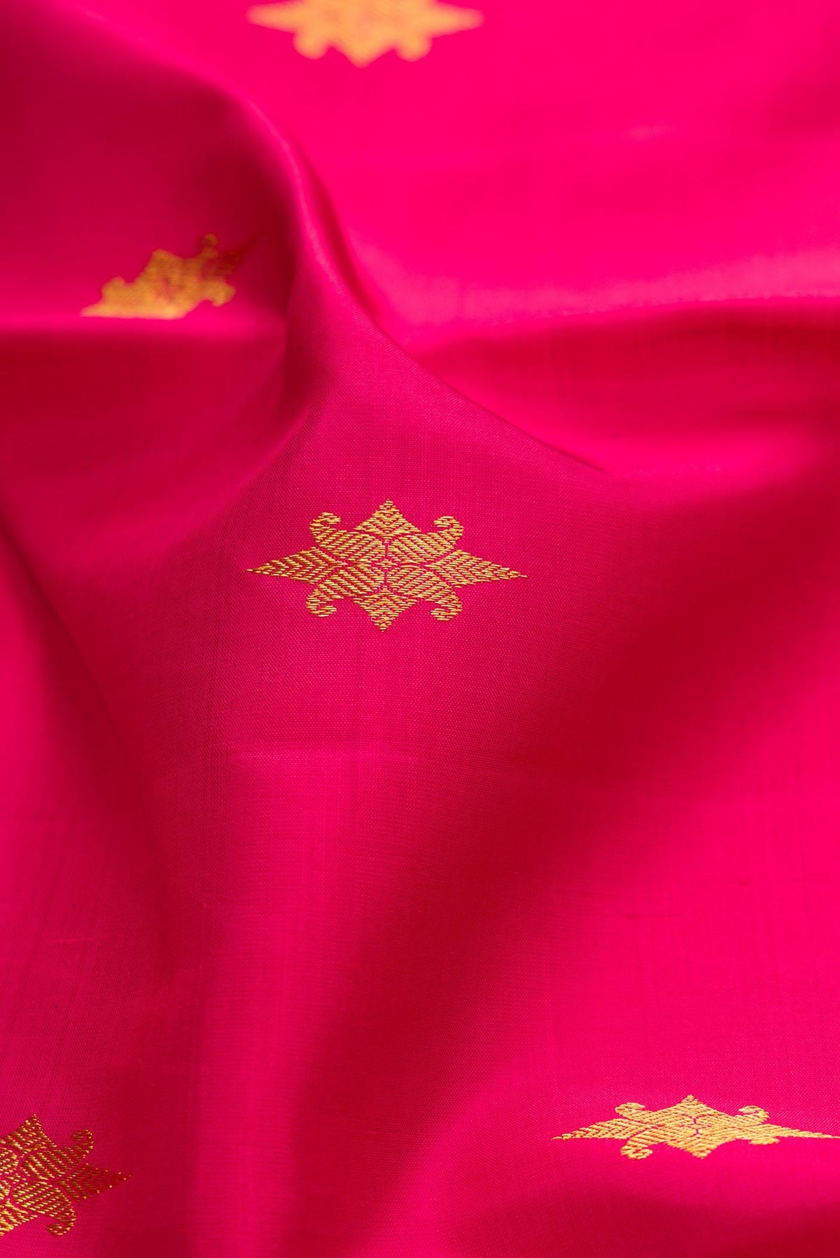 Close up of Pink Dual Tone Kanchipuram Silk Saree with Zari Butta on the body and Zari Border displaying folds
