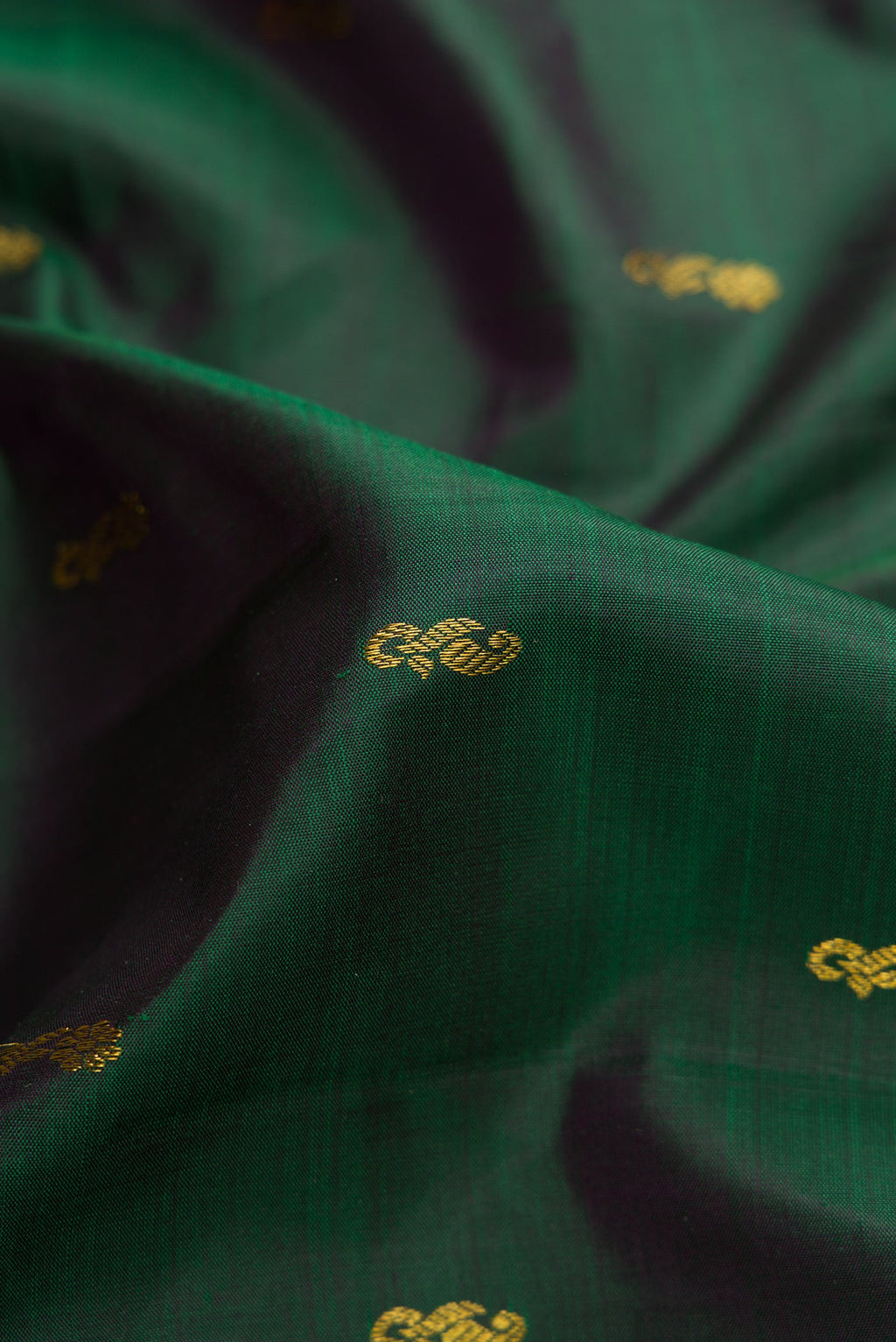 Close up of Bottle Green Dual Tone Kanjivaram Silk Saree with Zari Butta on the body and Zari Border.  displaying folds