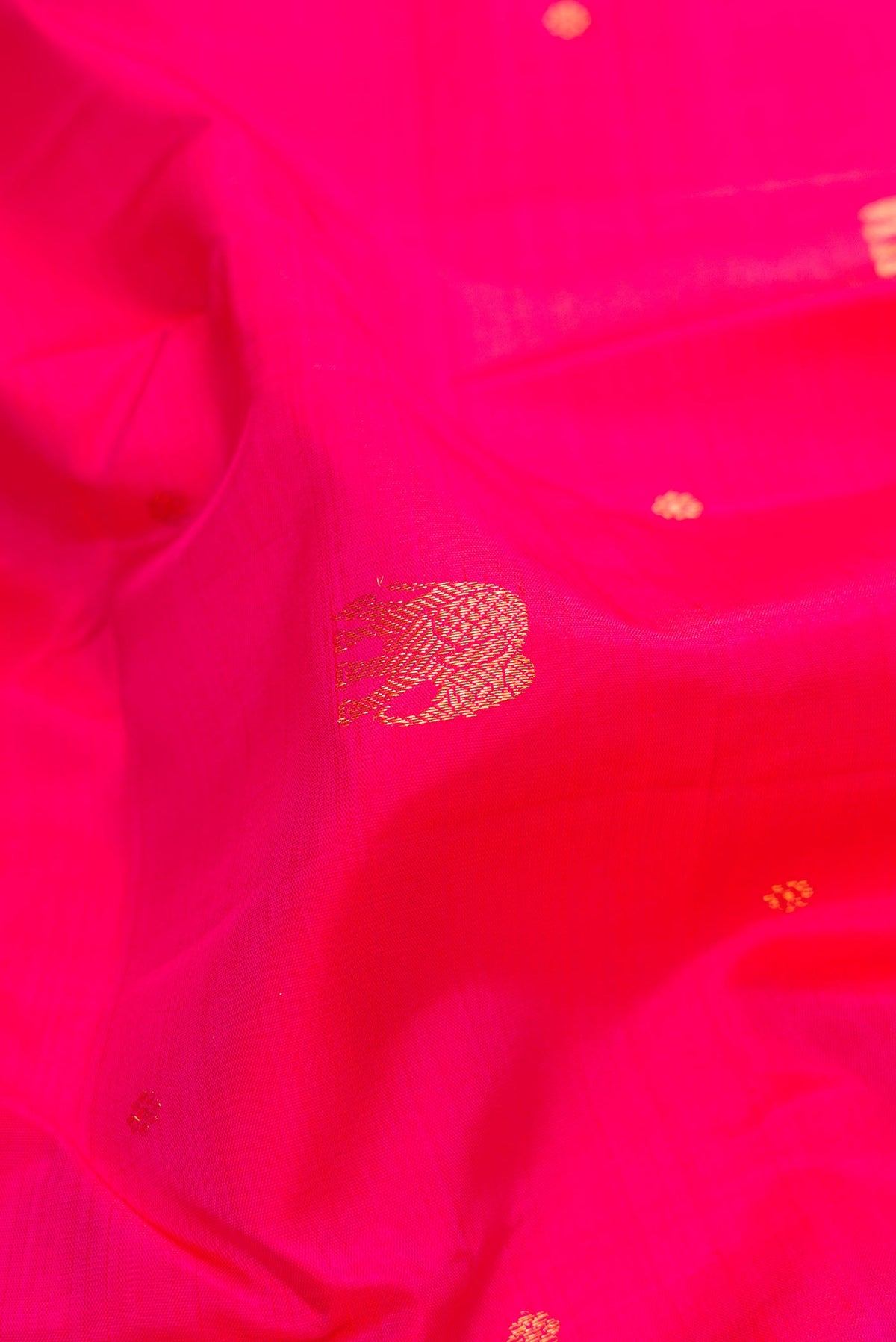 Close up of Pink Dual Tone Kanchipuram Silk Saree with Zari Butta on the body and Zari Border.  displaying folds