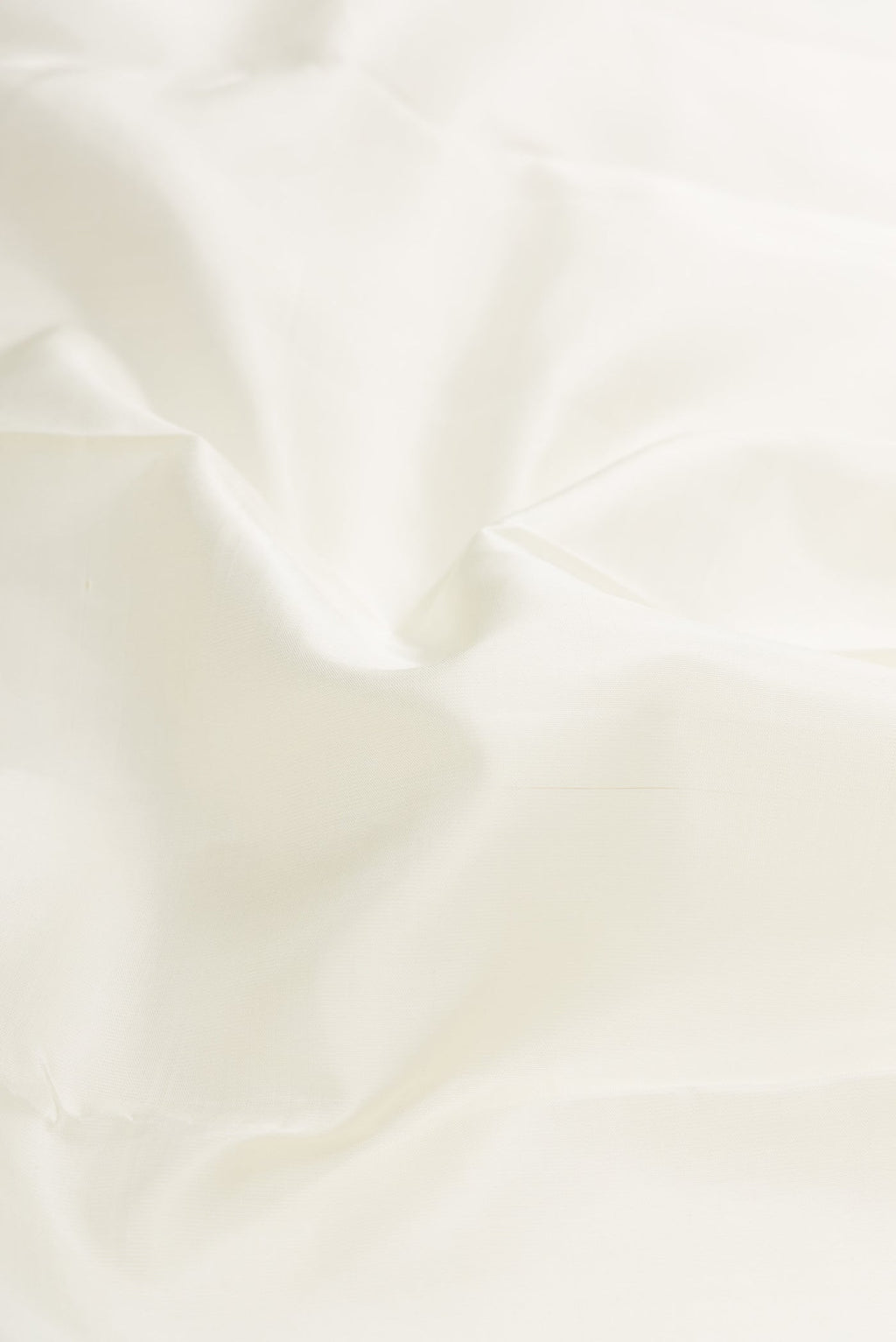 Close up of Pure Silk Pure Zari White Dual Tone Kanjivaram Saree with Plain Body and Zari Border.  displaying folds