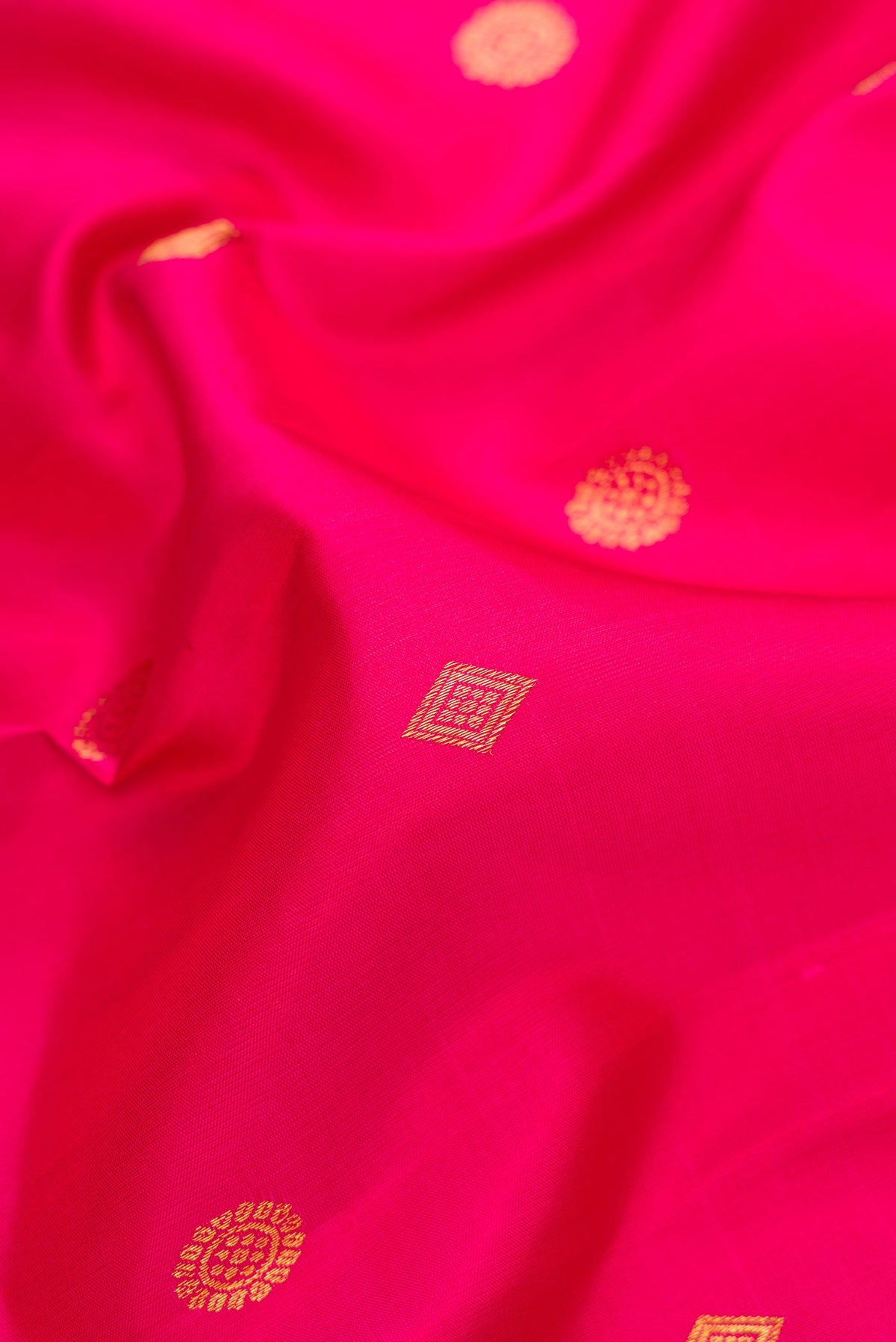 Close up of Pink Dual Tone Kanjivaram Silk Saree with Zari Butta on the body and Zari Border.  displaying folds