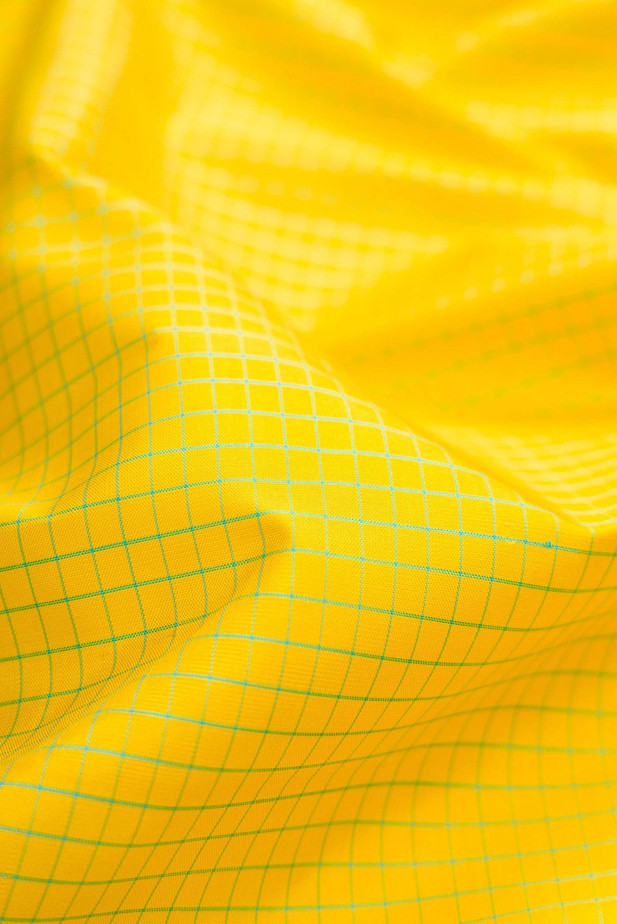 Close up of Lemon Yellow Dual Tone Kanchipuram Silk Saree with Checked design on the body and Zari Border displaying folds