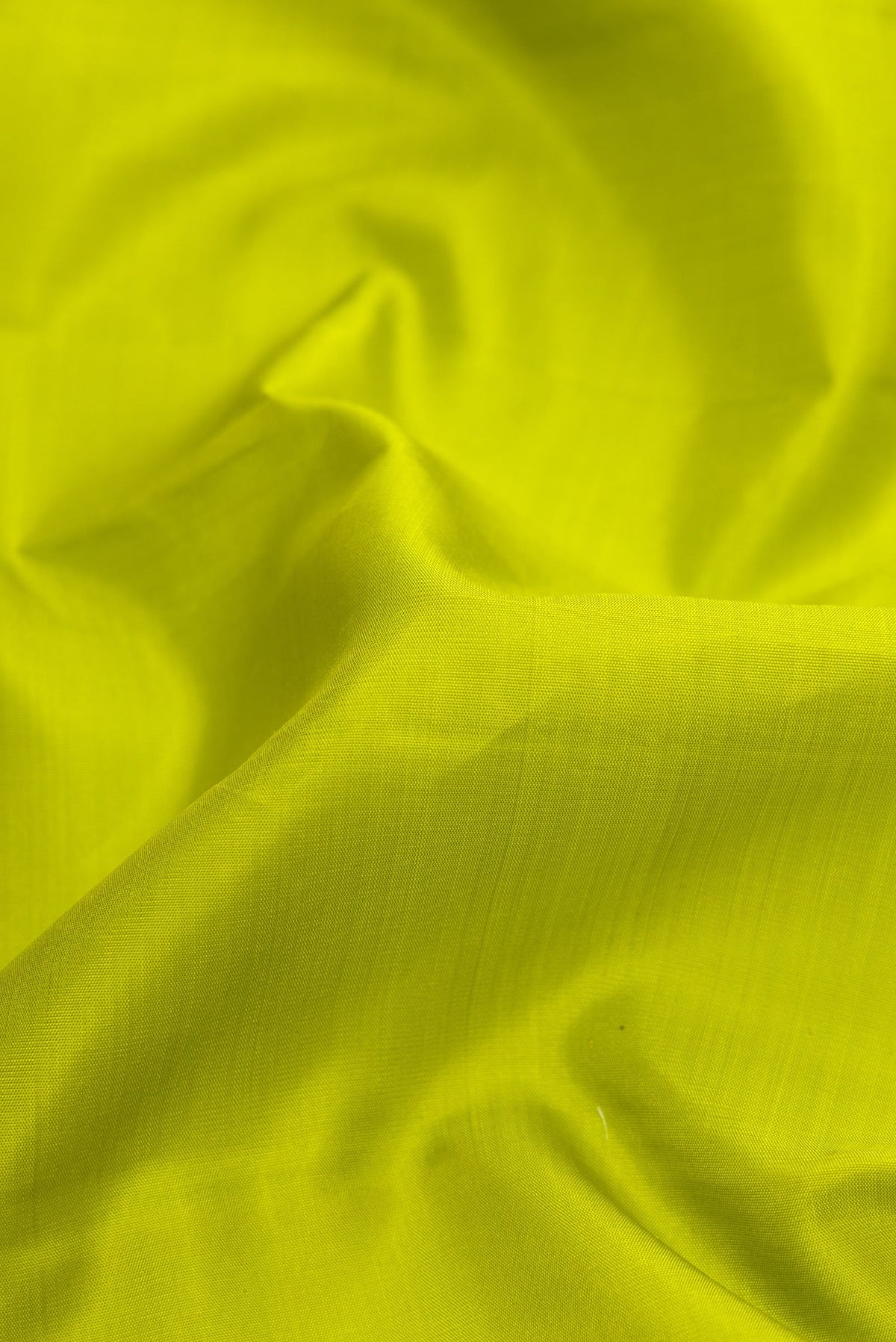Close up of Parrot Green Dual Tone Kanjivaram Silk Saree with Plain Body and Zari Border.  displaying folds