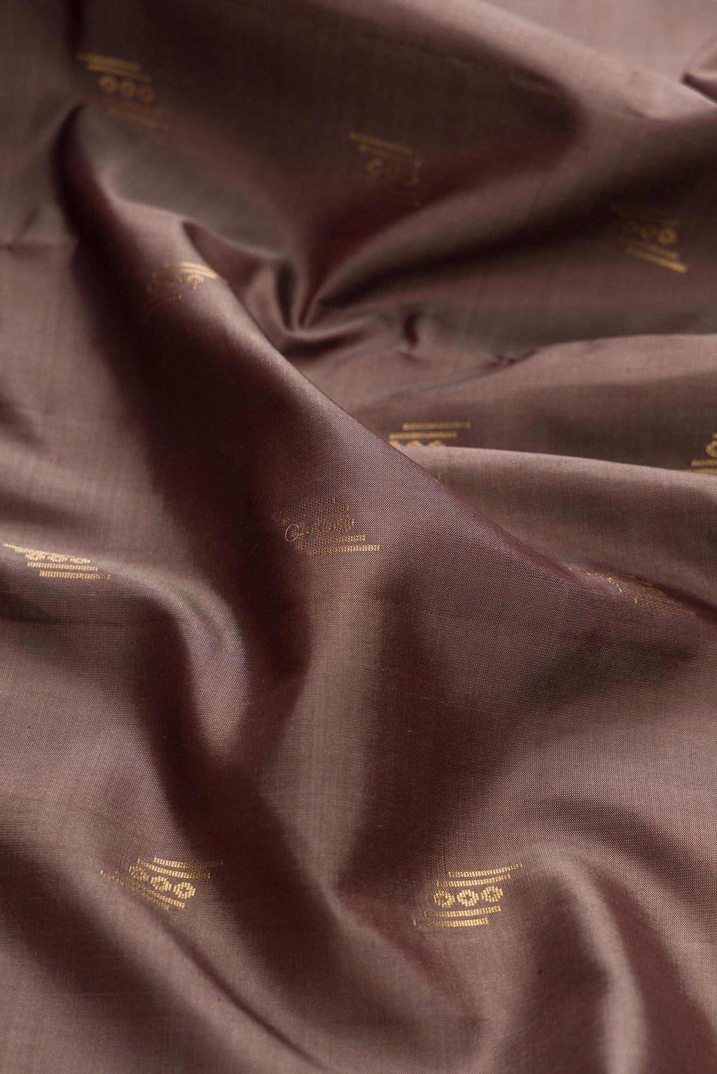 Close up of Brown Dual Tone Soft Silk Saree with Zari Butta on the body and Zari Border displaying folds