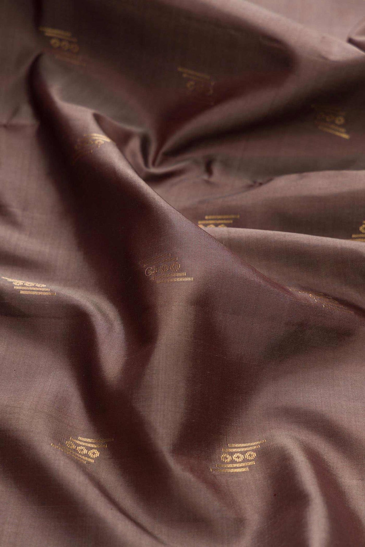 Close up of Brown Dual Tone Soft Silk Saree with Zari Butta on the body and Zari Border displaying folds