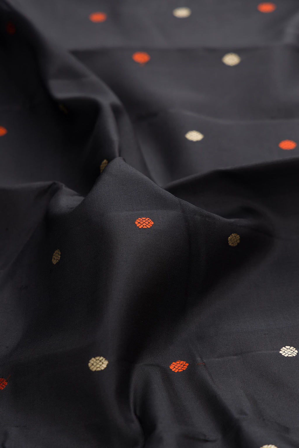 Close up of Black Dual Tone Kanchipuram Silk Saree with Thread Butta on the body and Thread Border displaying folds