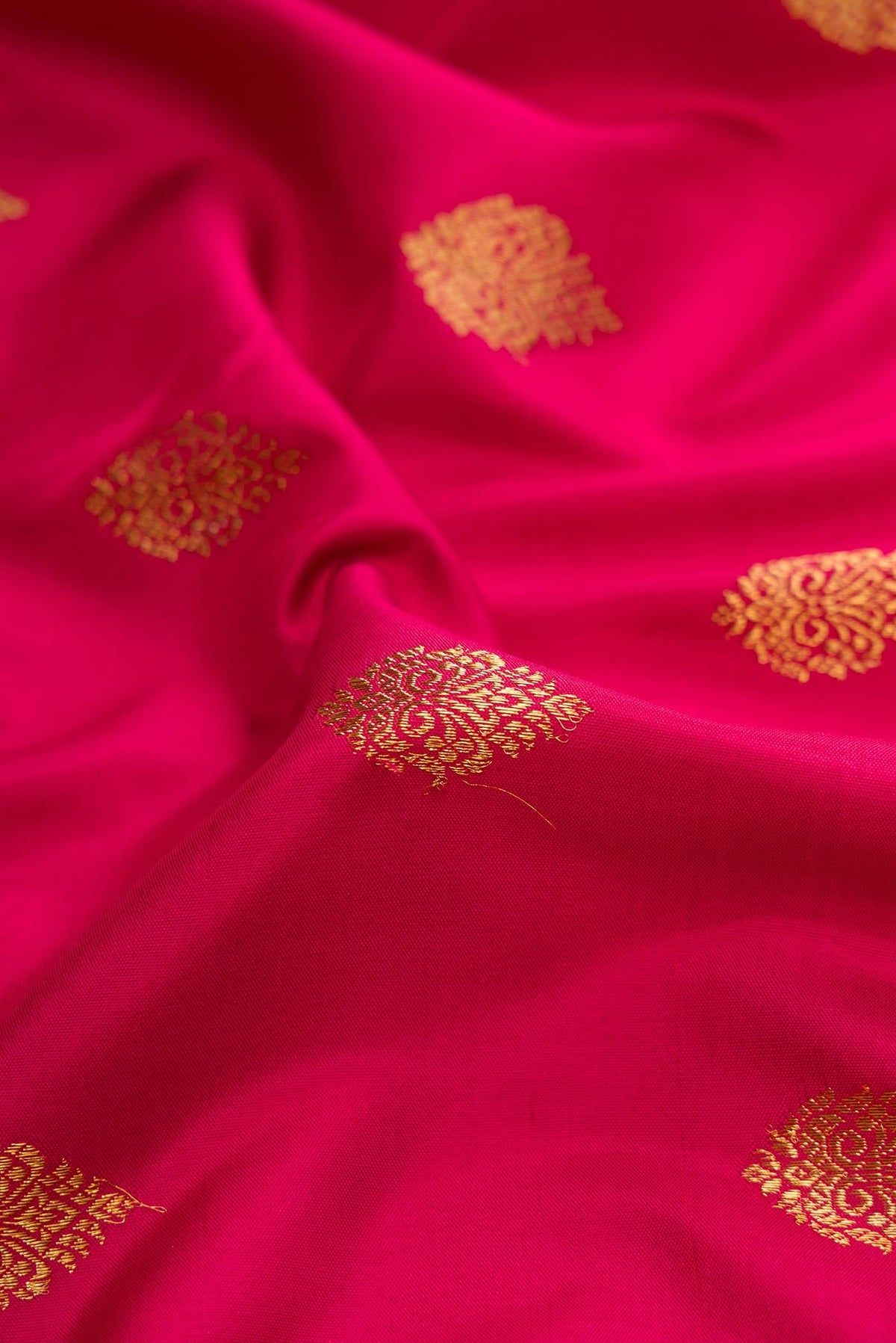 Close up of Pure Silk Pure Zari Dark Pink Dual Tone Kanjivaram Saree with Zari Butta on the body and Zari Border.  displaying folds
