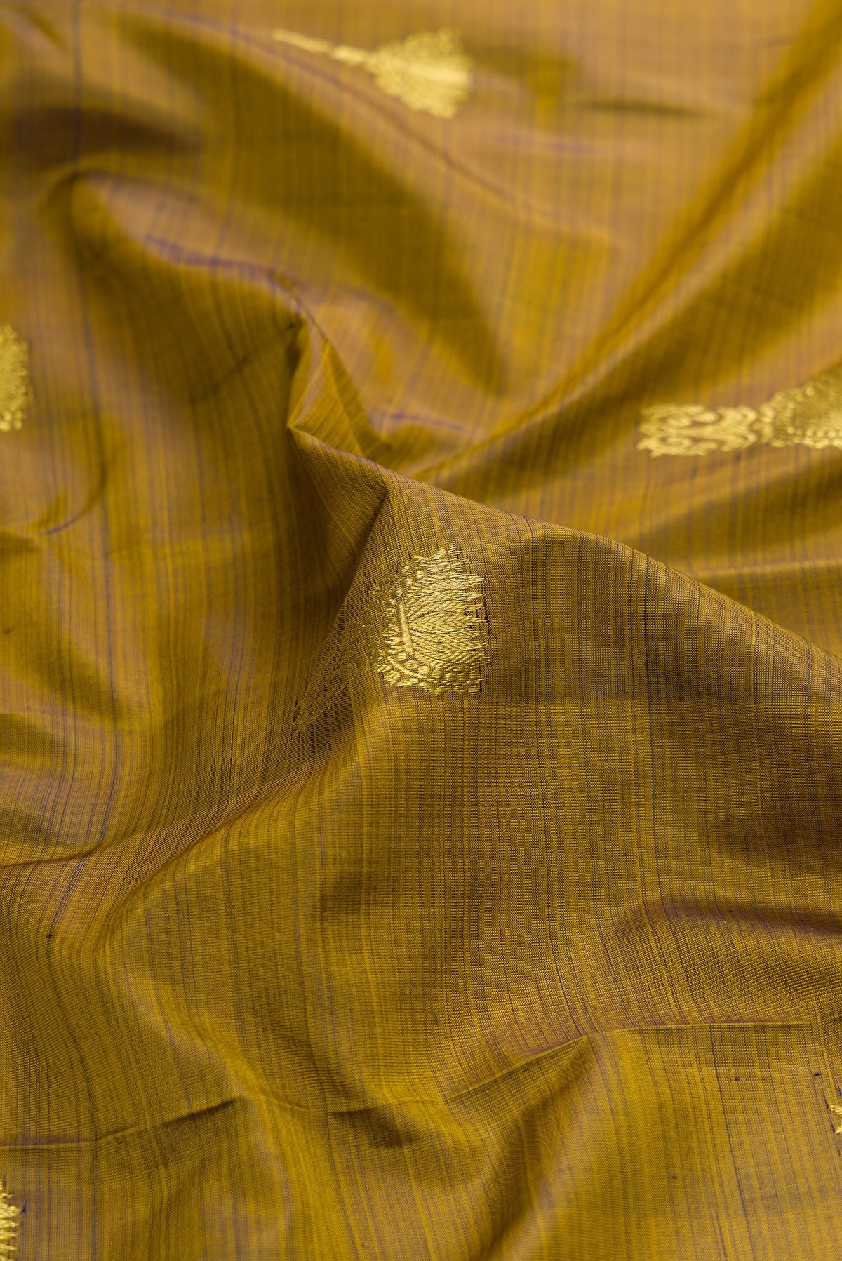 Close up of Mehandi Green Dual Tone Kanchipuram Silk Saree with Zari Butta on the body and Zari Border.  displaying folds