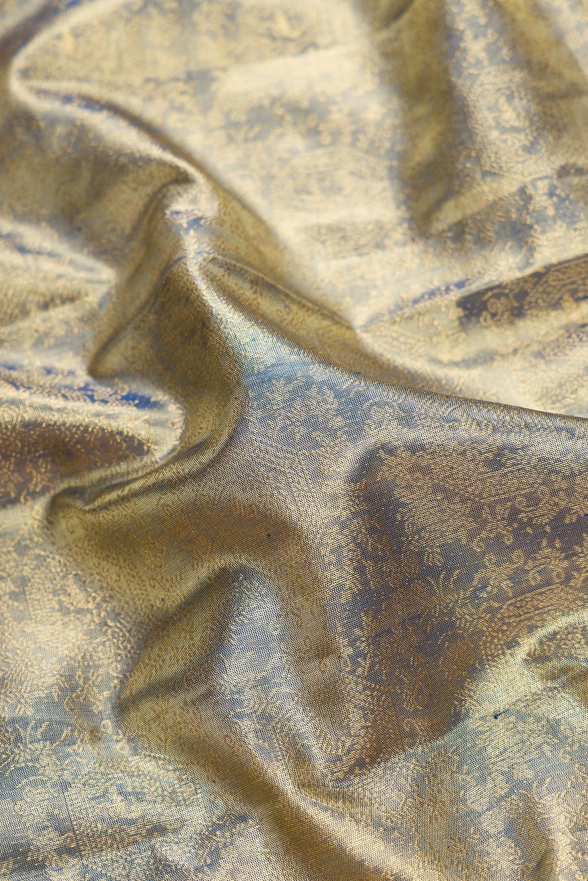 Close up of Green Dual Tone Kanjivaram Tissue Silk Saree with Zari Brocade on the body and Zari Border.  displaying folds