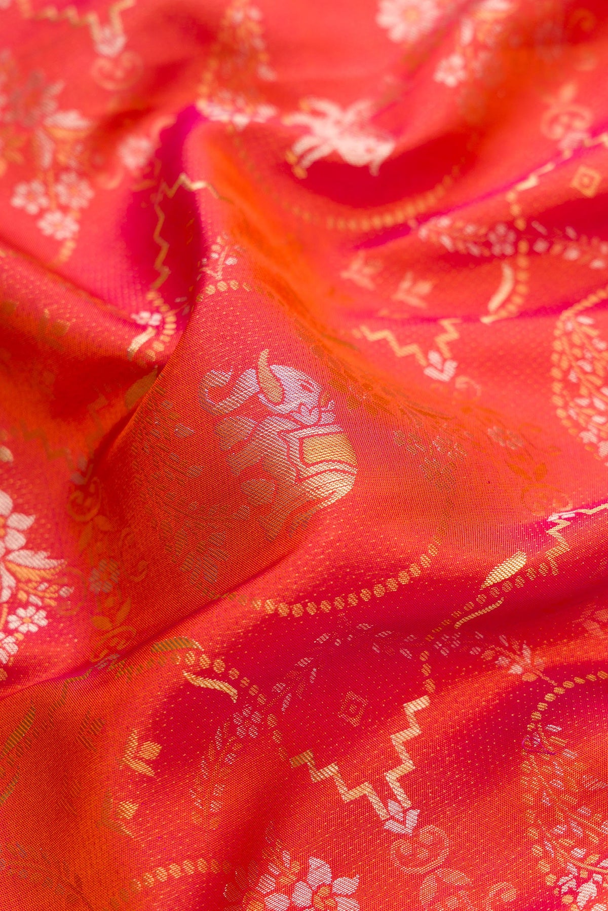 Close up of Brick Orange Dual Tone Kanjivaram Silk Saree with Zari Brocade on the body and Zari Border.  displaying folds