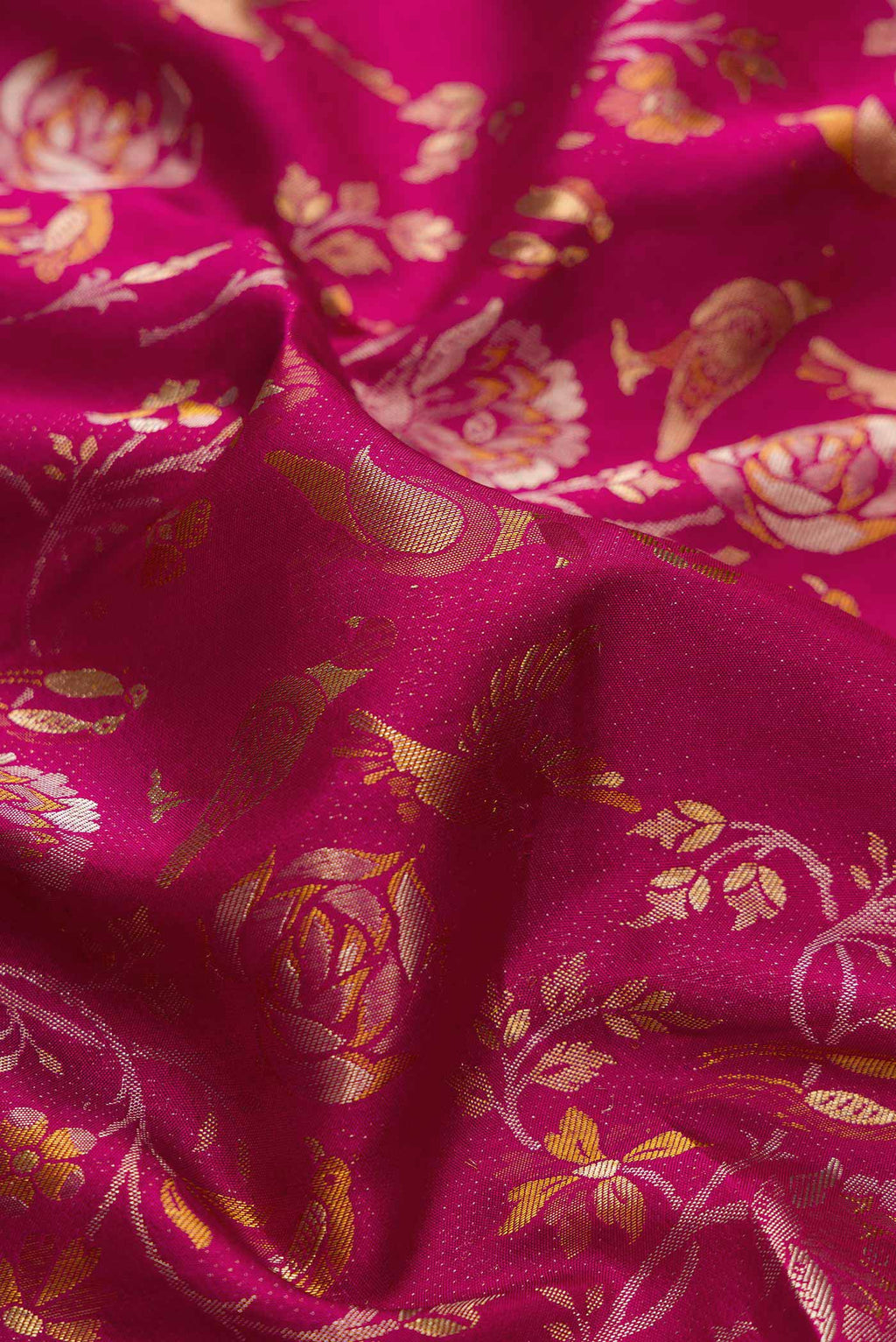 Close up of Magenta Dual Tone Kanjivaram Silk Saree with Zari Brocade on the body and Zari Border.  displaying folds