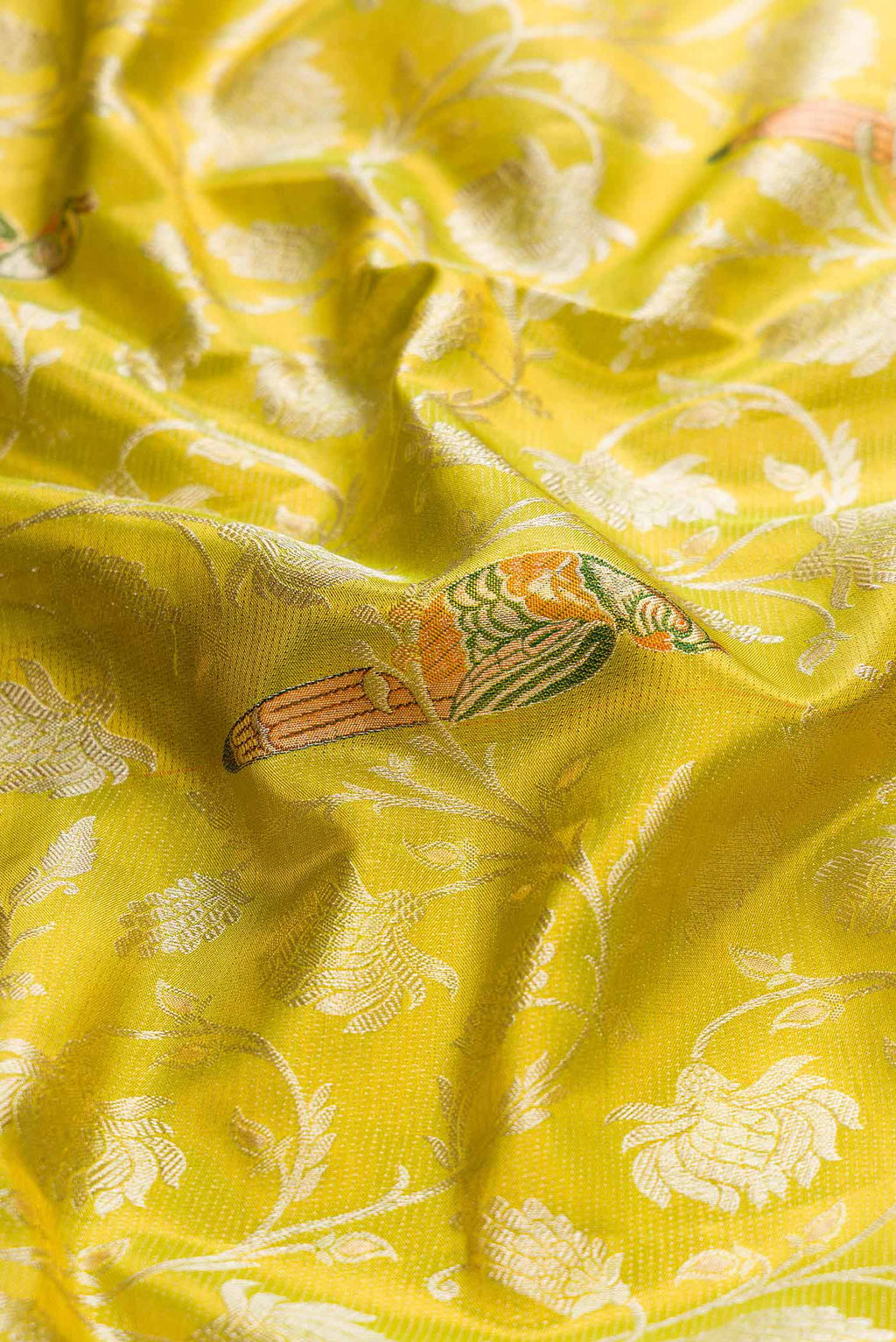 Close up of Parrot Green Dual Tone Kanchipuram Tissue Silk Saree with Zari Brocade on the body and Zari Border displaying folds