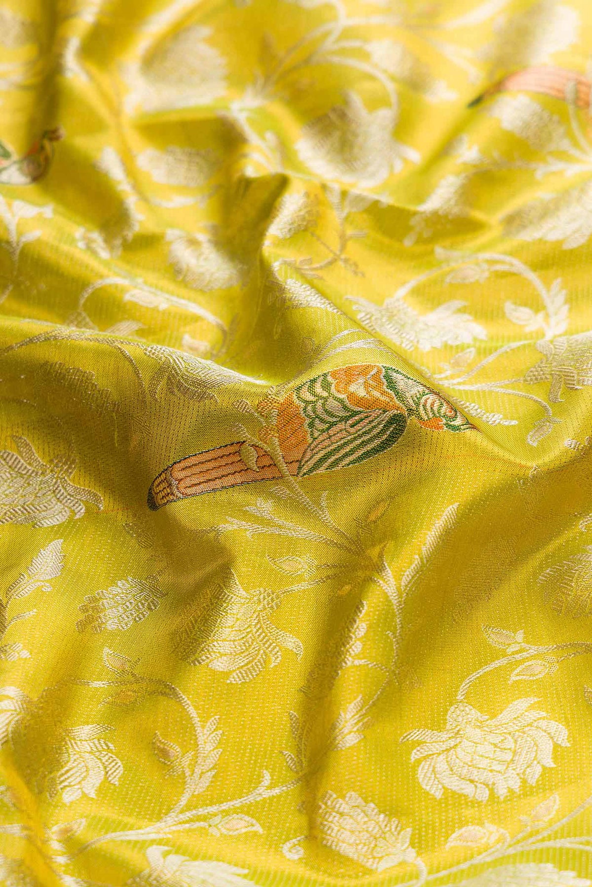 Close up of Parrot Green Dual Tone Kanchipuram Tissue Silk Saree with Zari Brocade on the body and Zari Border displaying folds