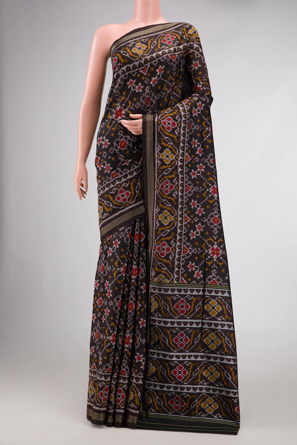 Black Dual Tone Rajkot Patola Silk Saree with Ikat Print on the body and Zari Border.  displayed on a mannequin