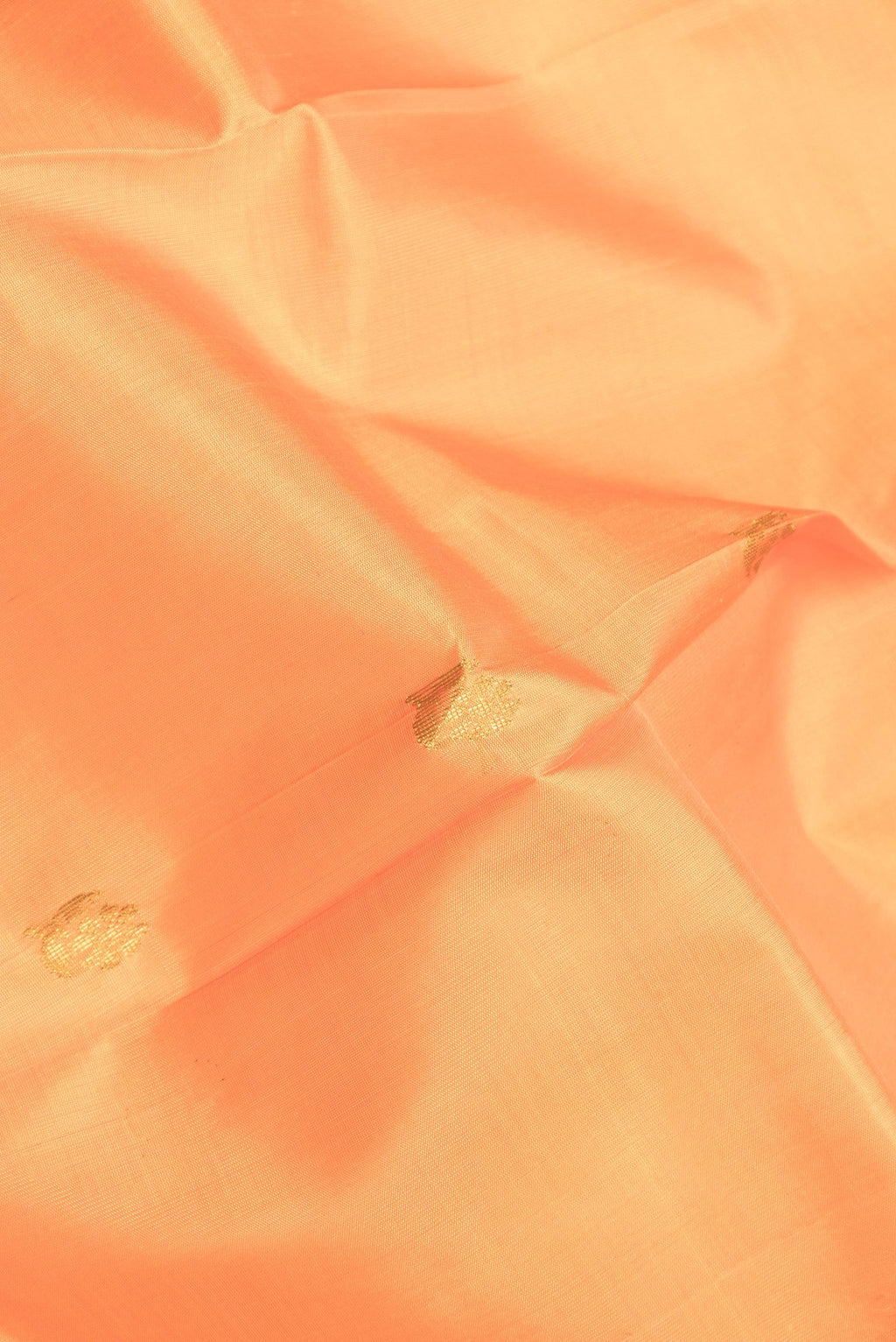 Close up of Orange Dual Tone Kanjivaram Silk Saree with Zari Butta on the body and One Side Border.  displaying folds