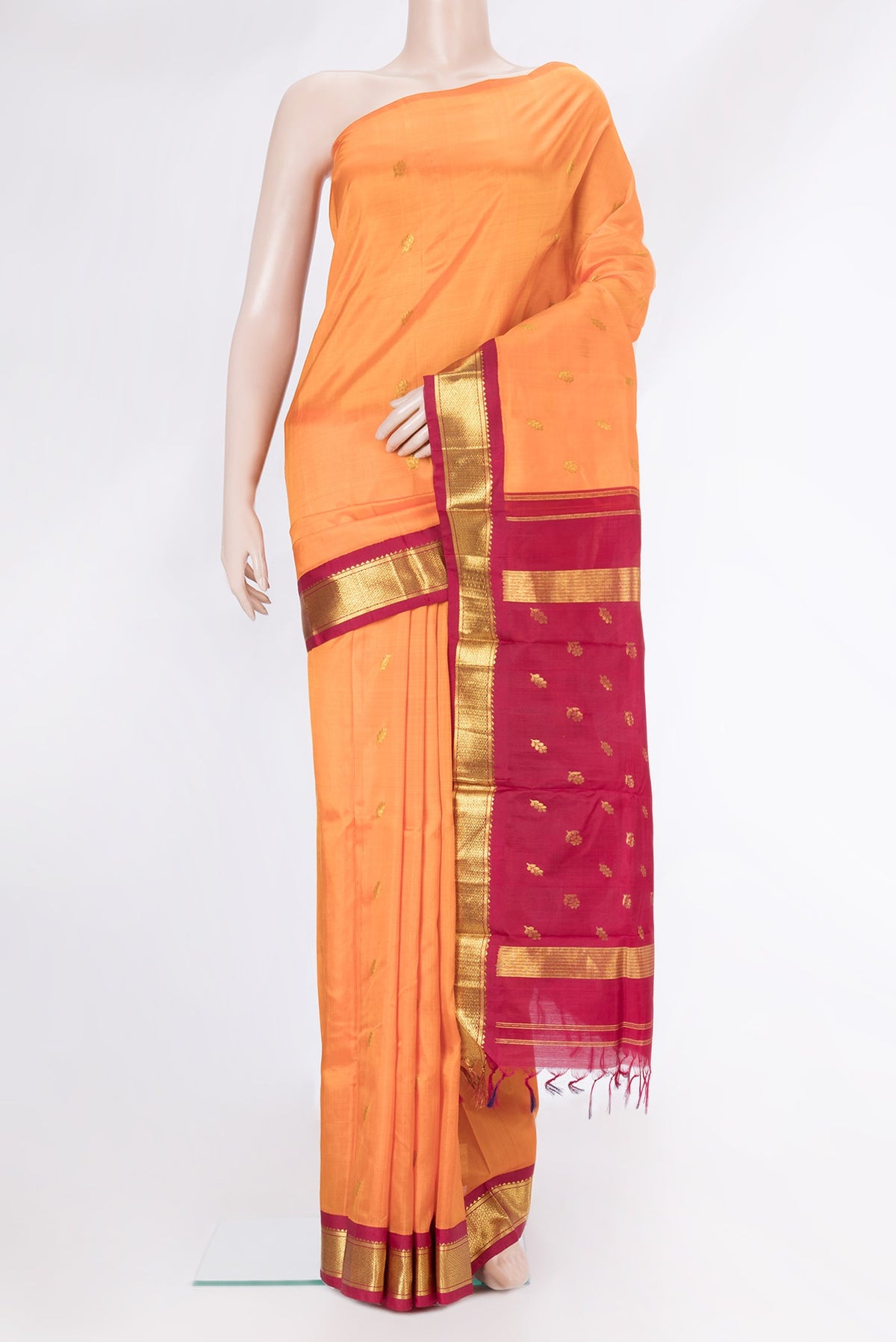 Orange Dual Tone Kanjivaram Silk Saree with Zari Butta on the body and One Side Border.  displayed on a mannequin