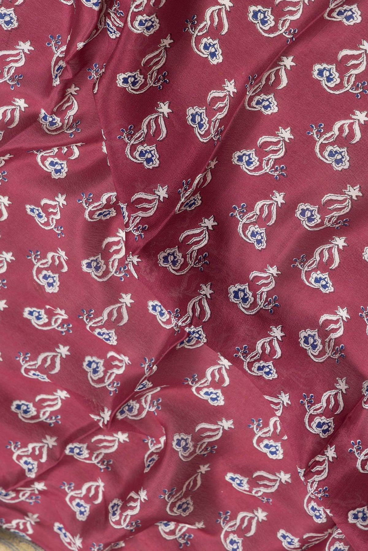 Close up of Maroon Dual Tone Mysore Crepe Saree with Printed design on the body and Zari Border.  displaying folds
