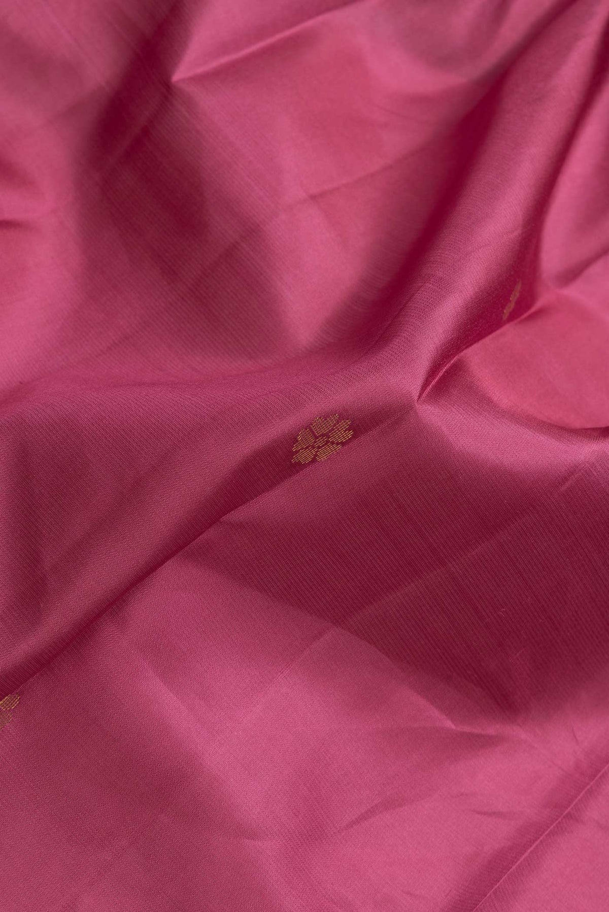 Close up of Dark Pink Dual Tone Kanjivaram Silk Saree with Zari Butta on the body and Zari Border.  displaying folds