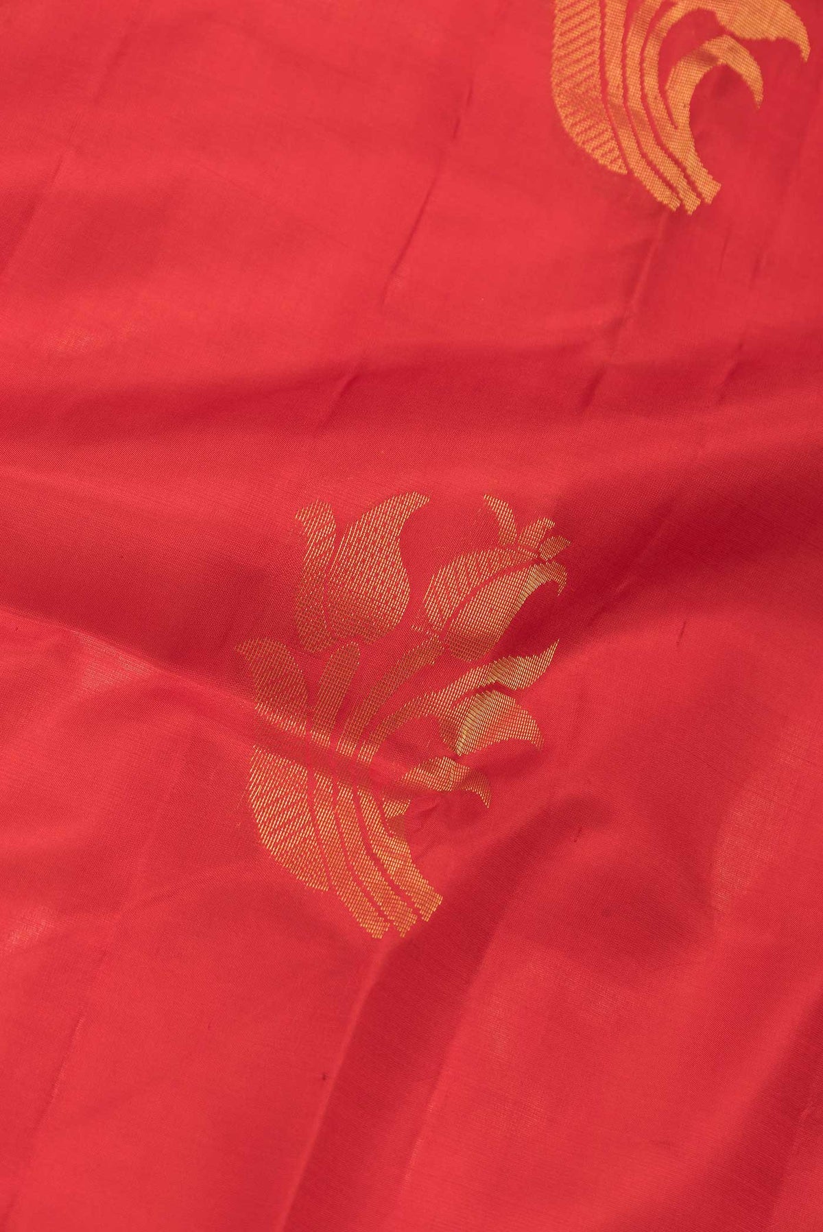 Close up of Red Dual Tone Soft Silk Saree with Zari Butta on the body and Zari Border.  displaying folds