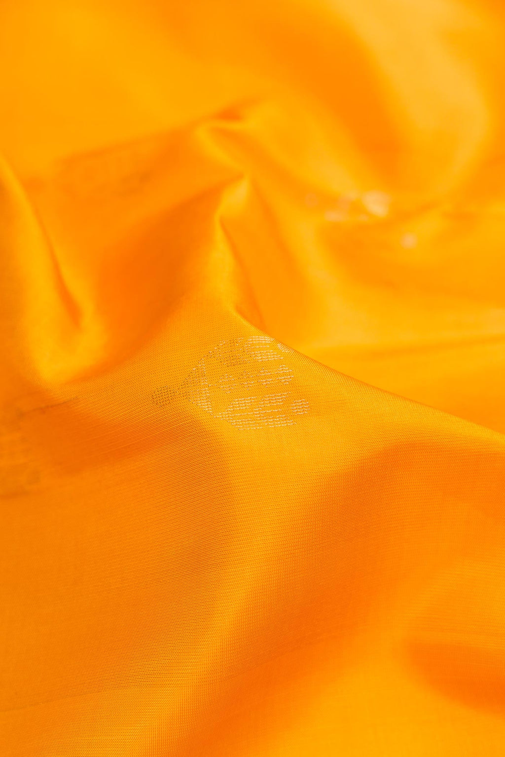Close up of Mustard Dual Tone Soft Silk Saree with Zari Butta on the body and Zari Border.  displaying folds