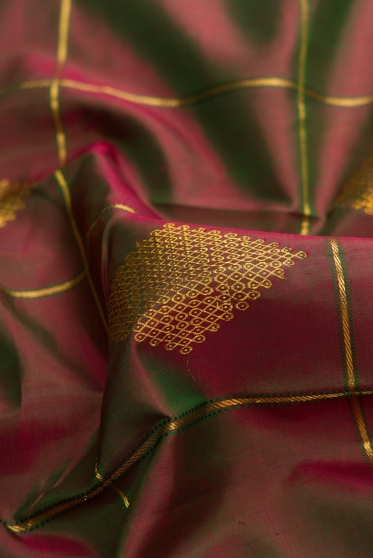 Close up of Green with Maroon Color Kanchipuram Silk Saree with Checked design on the body and Thin Zari Line.  displaying folds