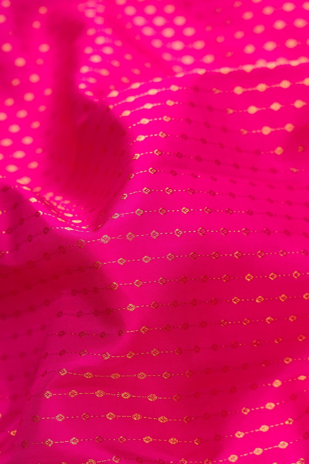 Close up of Pink Dual Tone Kanchipuram Silk Saree with Stripes on the body and Zari Border.  displaying folds