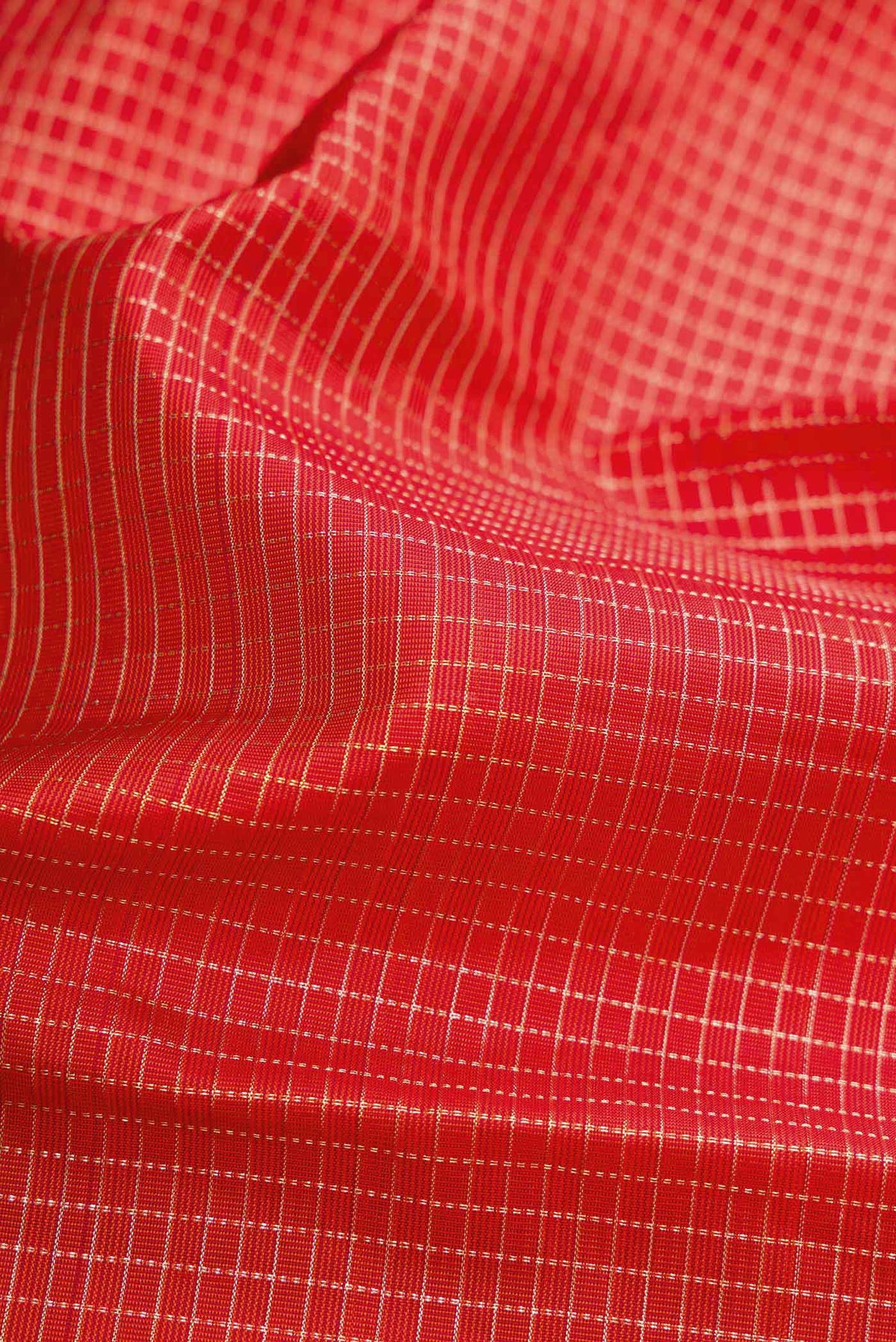Close up of Orange Dual Tone Kanchipuram Silk Saree with Checked design on the body and Zari Border.  displaying folds